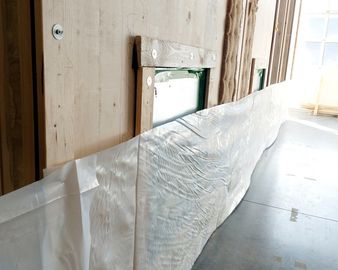 Die dreidimensionalen Massivholz-Module werden mit einer recycelbaren Schrumpfflachfolie abgedeckt.