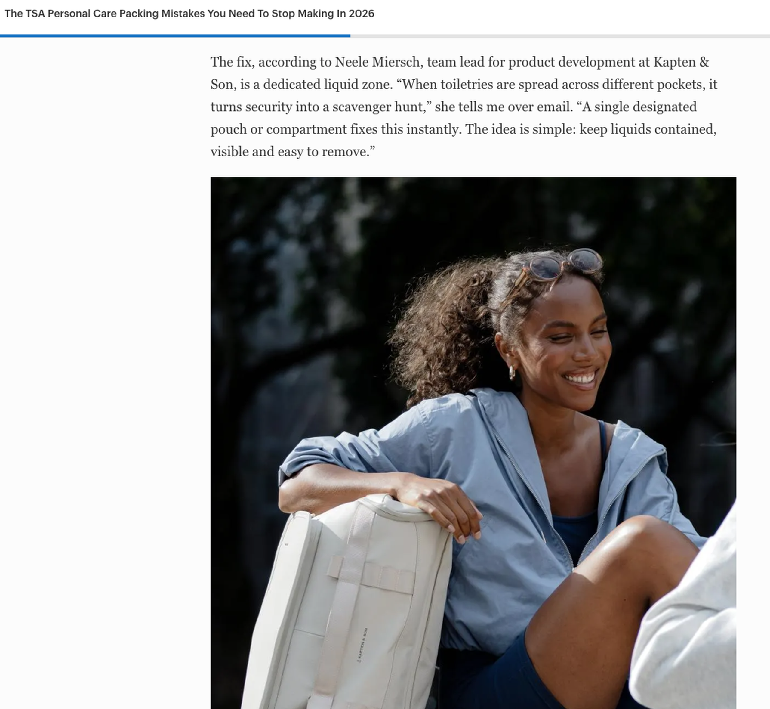 Woman smiling outdoors holding a Kapten & Son backpack, featured in an article about TSA packing tips with a quote from Kapten & Son's team lead for product development.