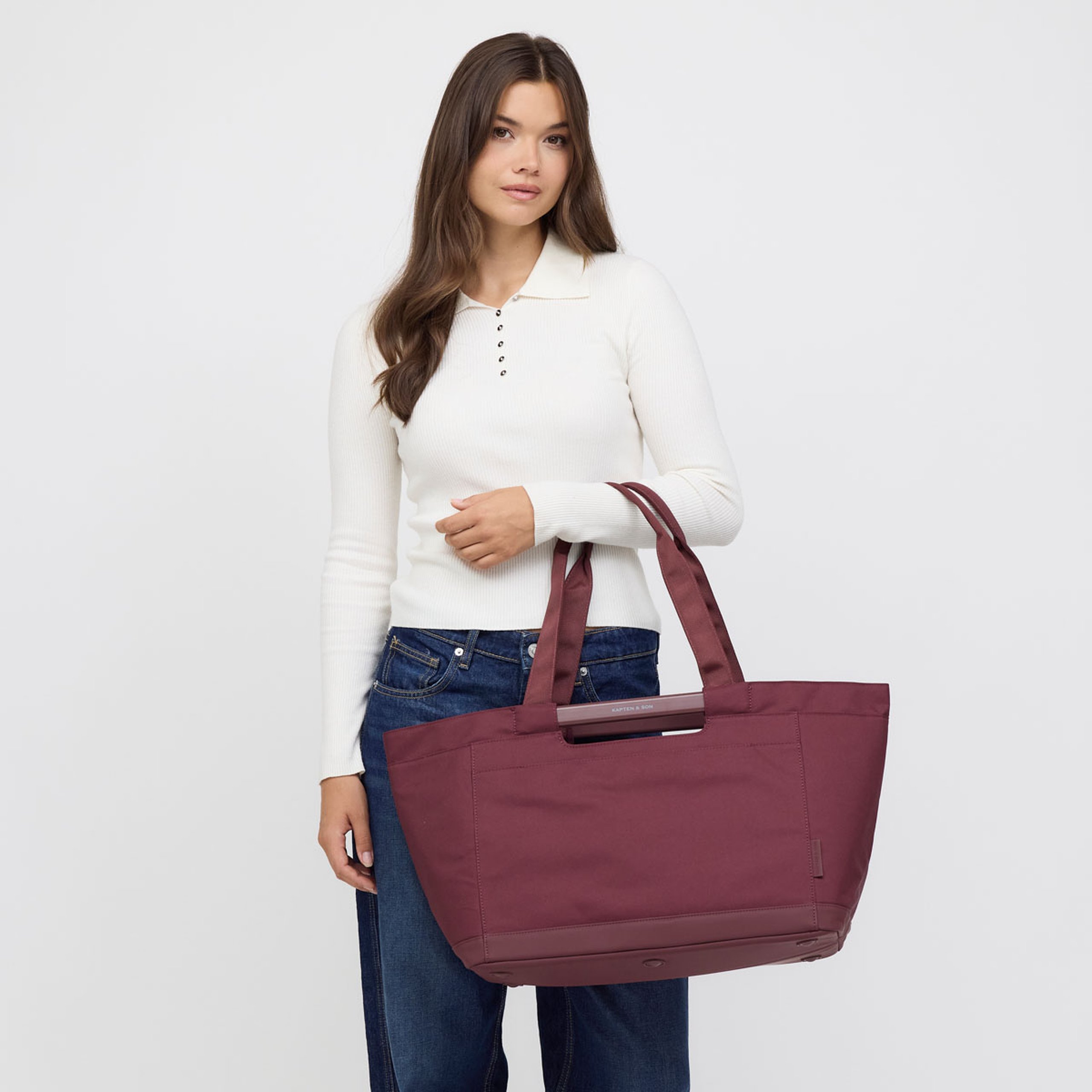 Woman holding a large shopping basket in front of her.