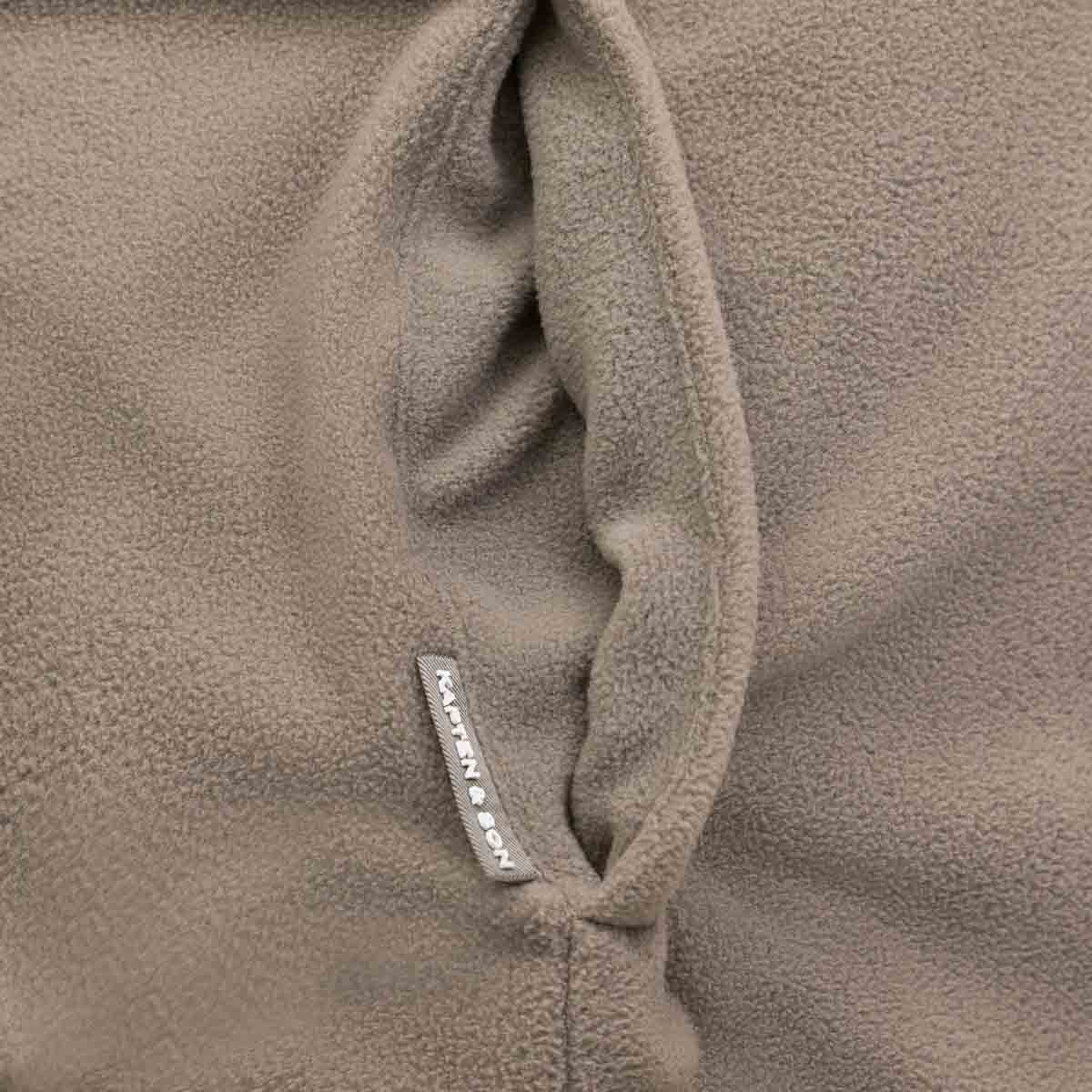 Nahaufnahme einer mit Fleece gefütterten Innentasche einer wendbaren Jacke mit Markenlabel