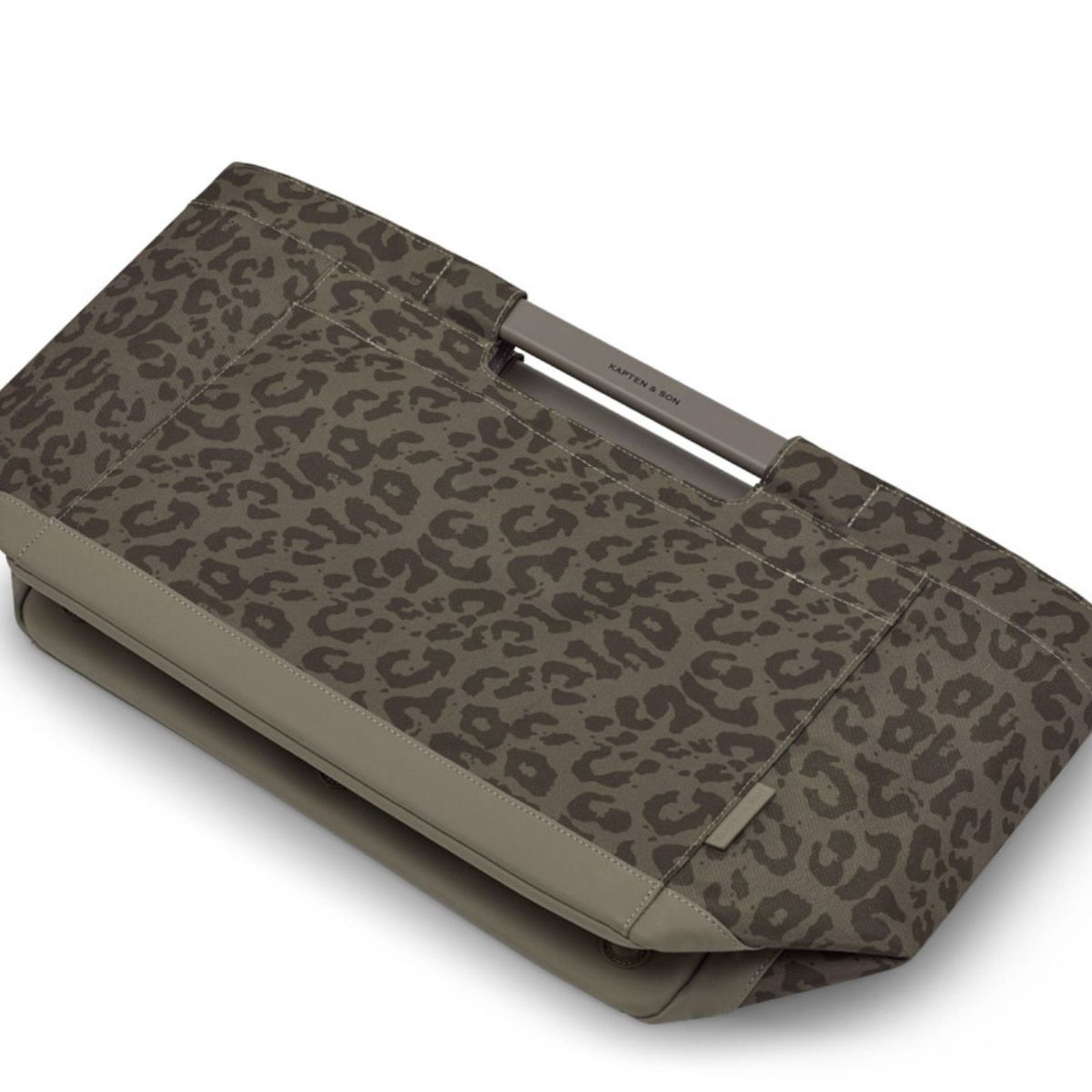 A minimalist shopping basket is shown lying flat on a white background. The bag features a sleek, structured design with clean lines and a subtle handle accent.