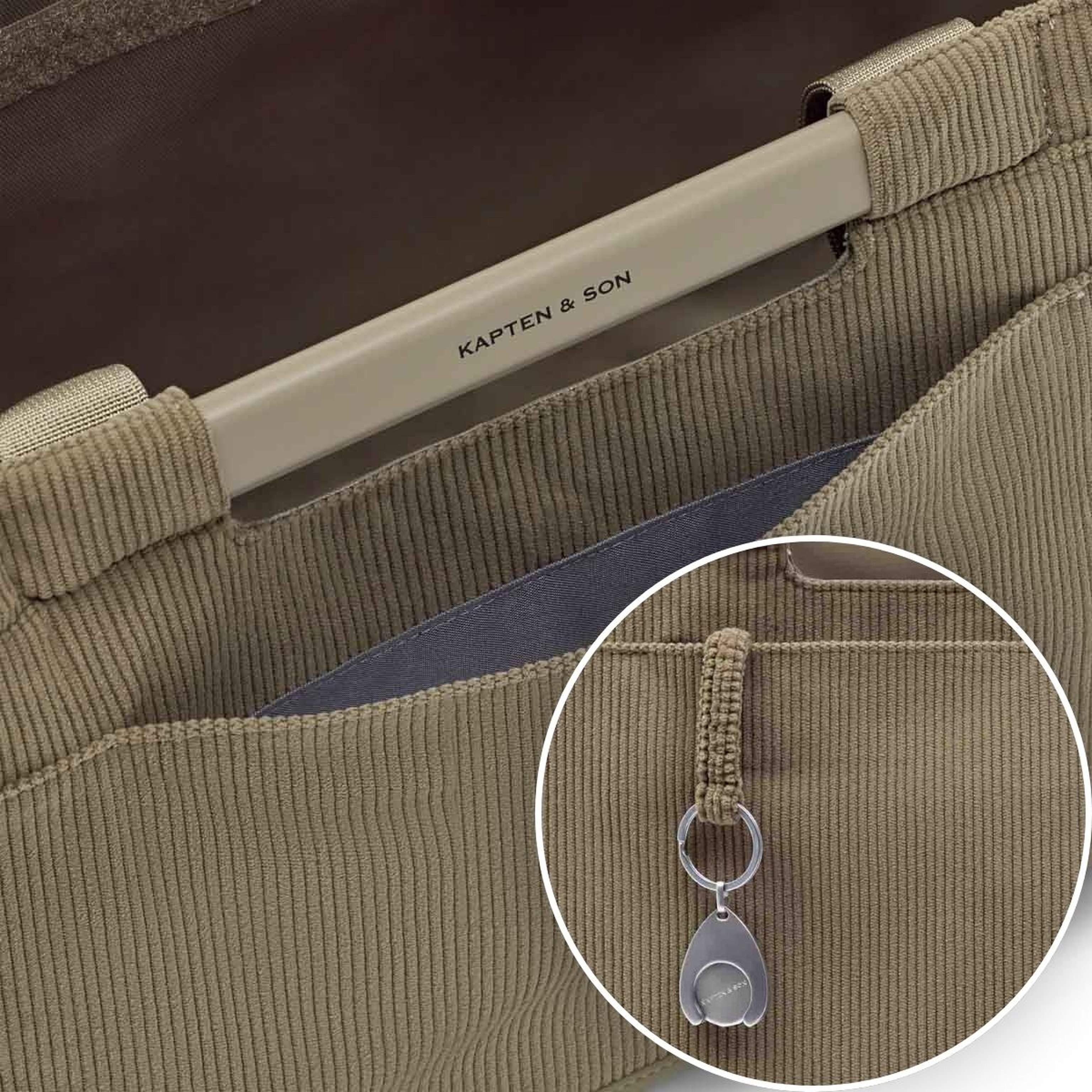 Close-up of a shopping basket with a sturdy handle on which „Kapten & Son" is printed. An inset detail shows the matching high-quality coin for the shopping trolley.