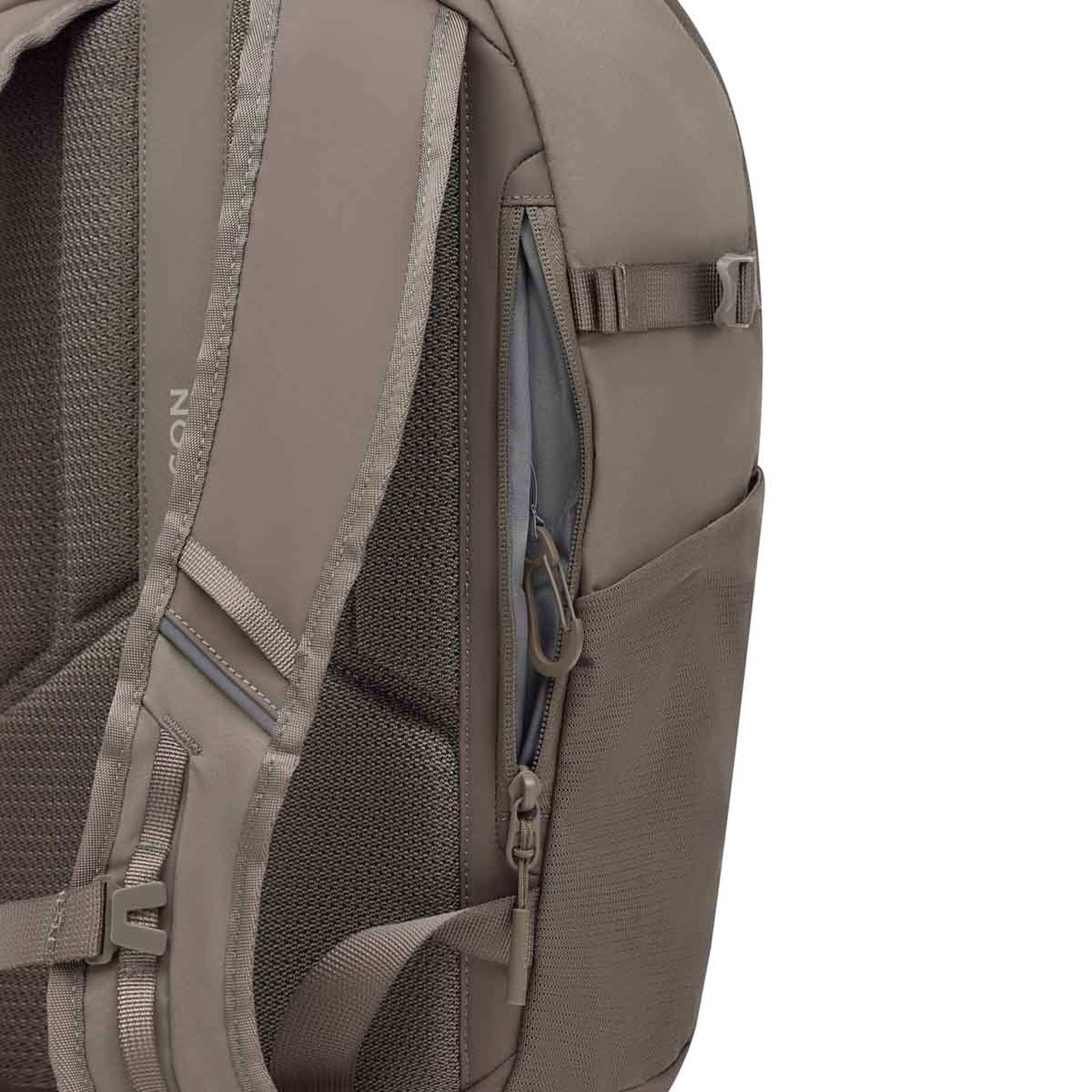 Nahaufnahme eines beigefarbenen Rucksacks mit Detailansicht der Seiten- und Rückenpartie. Eine seitliche Reißverschlusstasche ist halb geöffnet und zeigt ein blaues Innenfutter. Das gepolsterte Rückenpanel und der Schulterriemen mit dem Kapten & Son Logo sind zu sehen, sowie weitere Gurte und Schnallen.