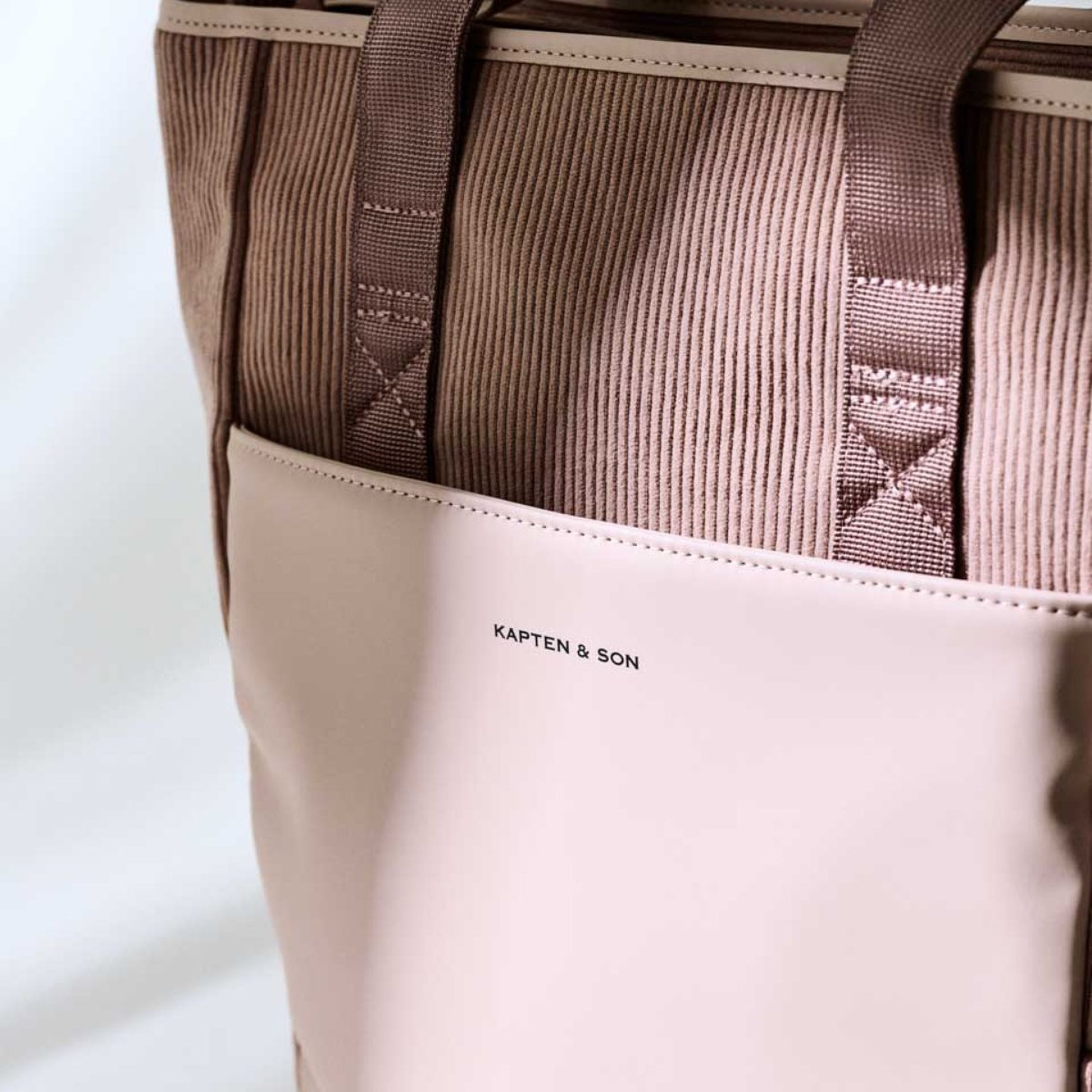 Uno zaino rosa con il nome “Kapten and Son” ben visibile sulla superficie.