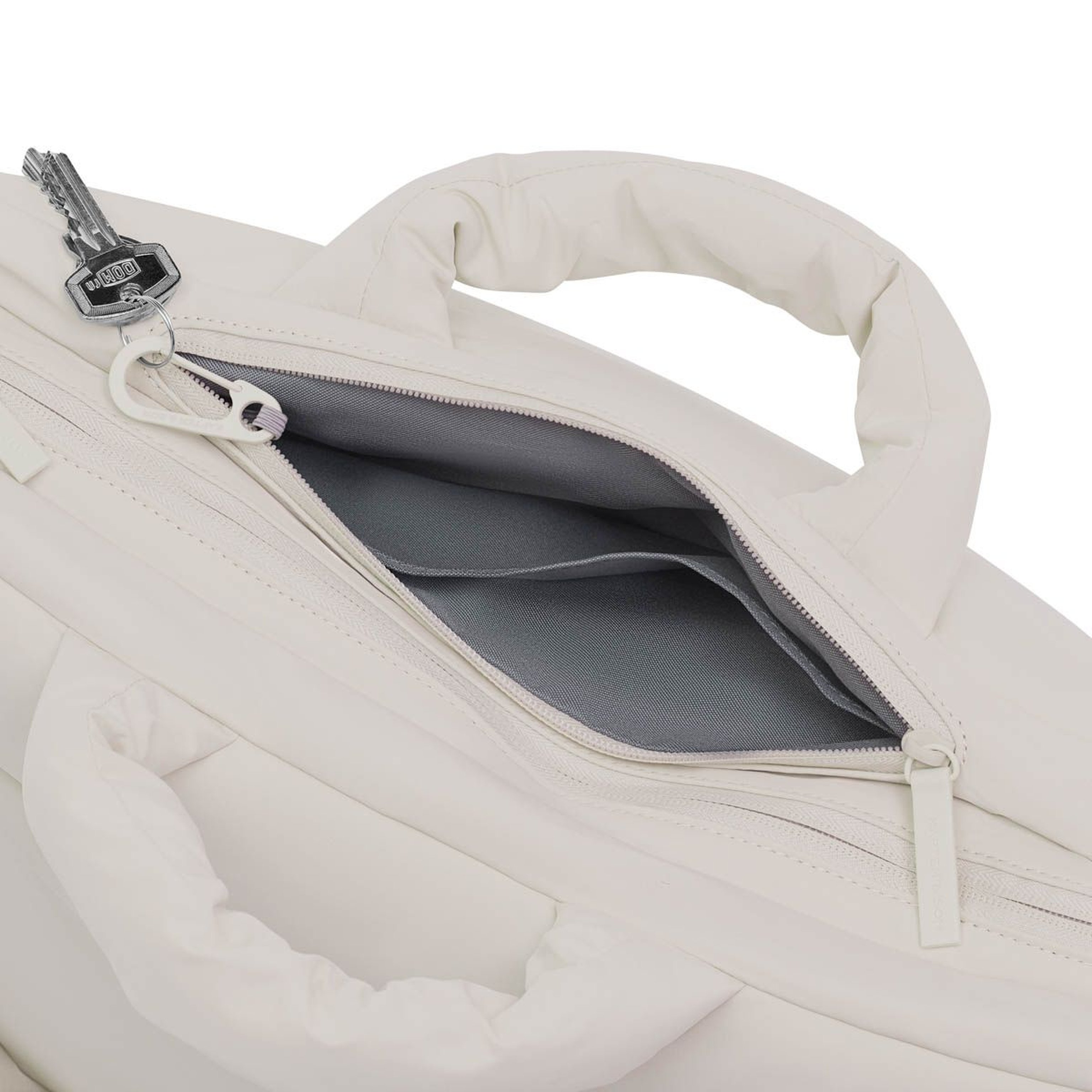 Gewatteerde handtas met gedeeltelijk open rits die een grijs interieur met een sleutelring onthult. Het design is strak en modern.