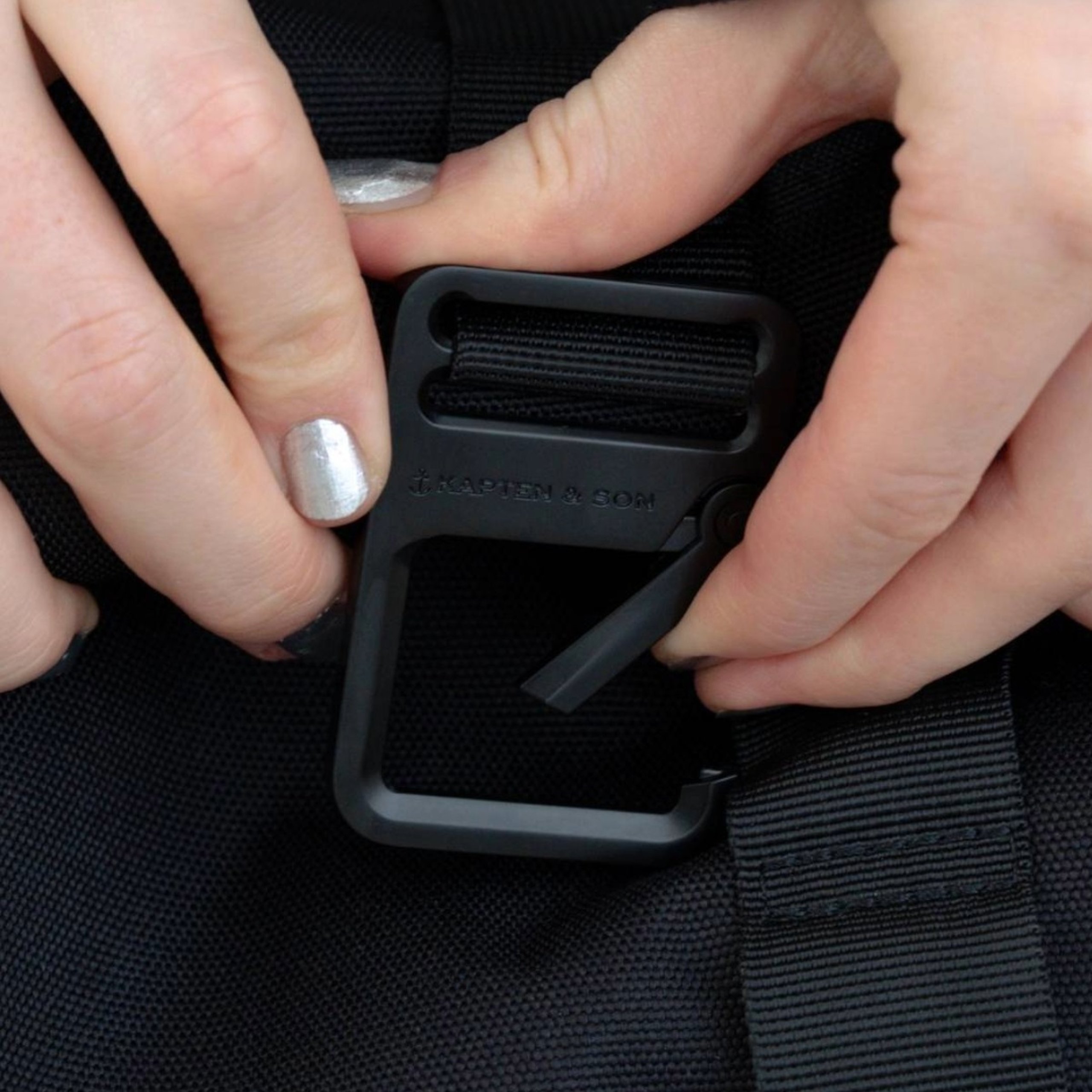 frauenhand öffnet schnalle eines rucksacks