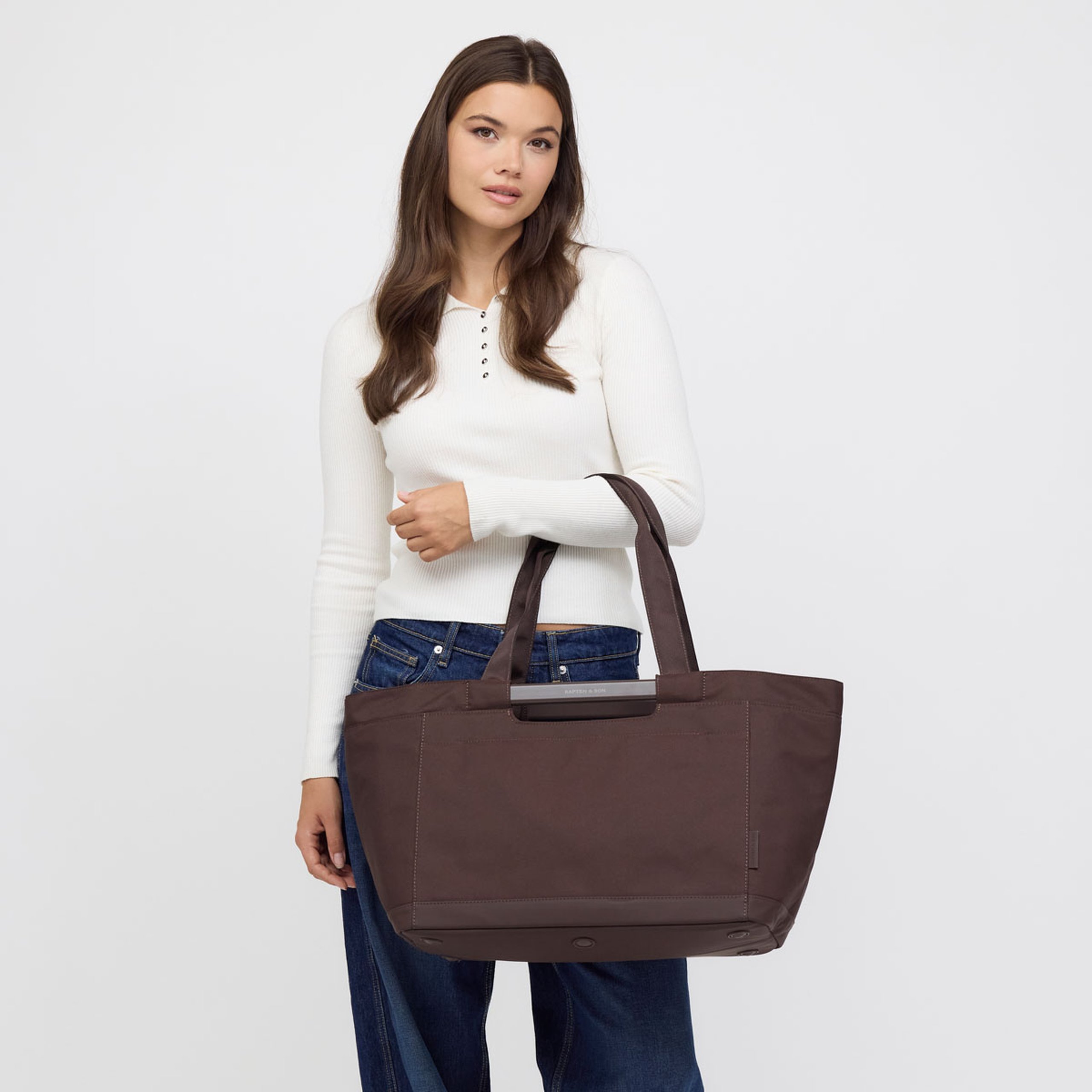 Woman holding a large shopping basket in front of her.