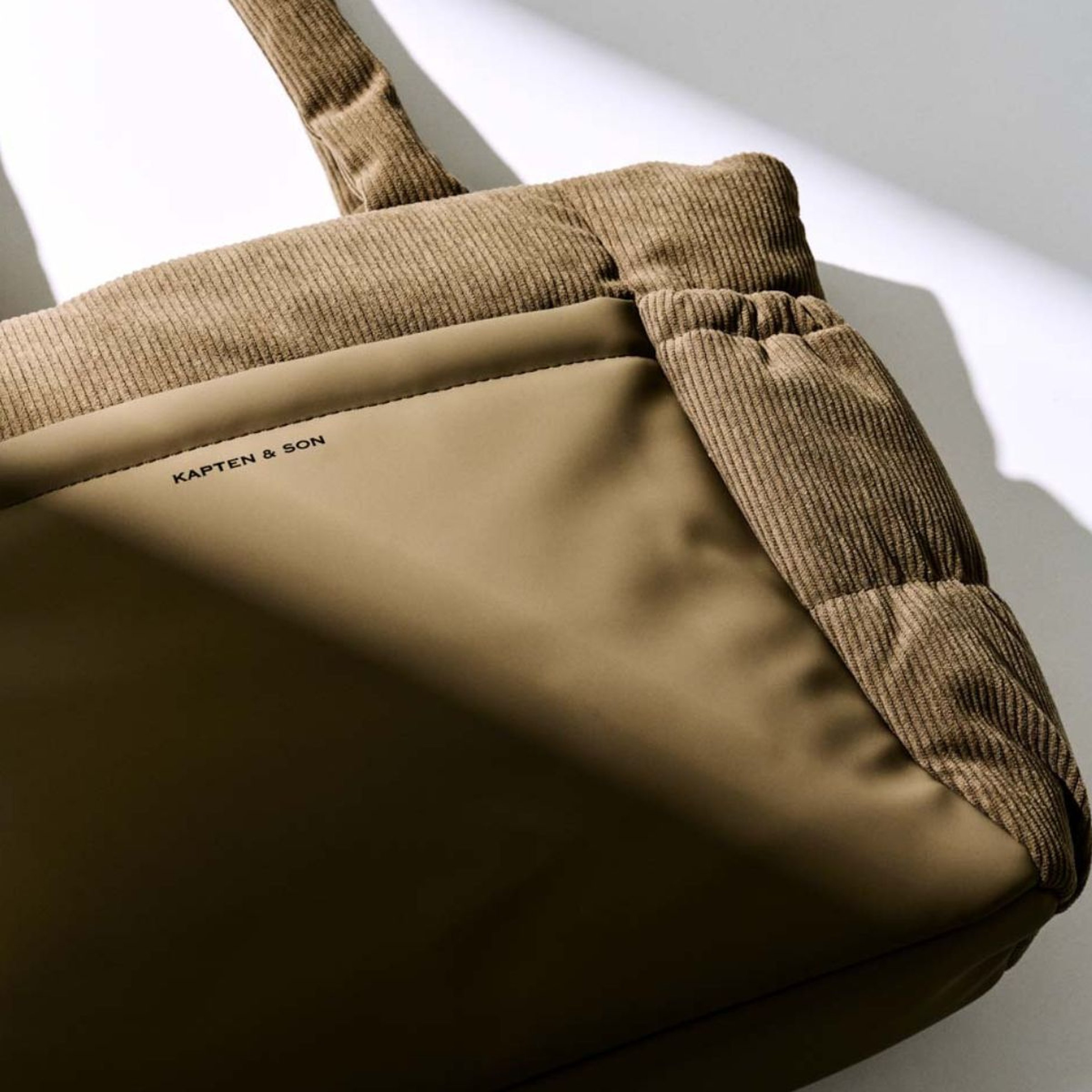 A green zippered bag, perfect for storage or travel, sits against a neutral background.