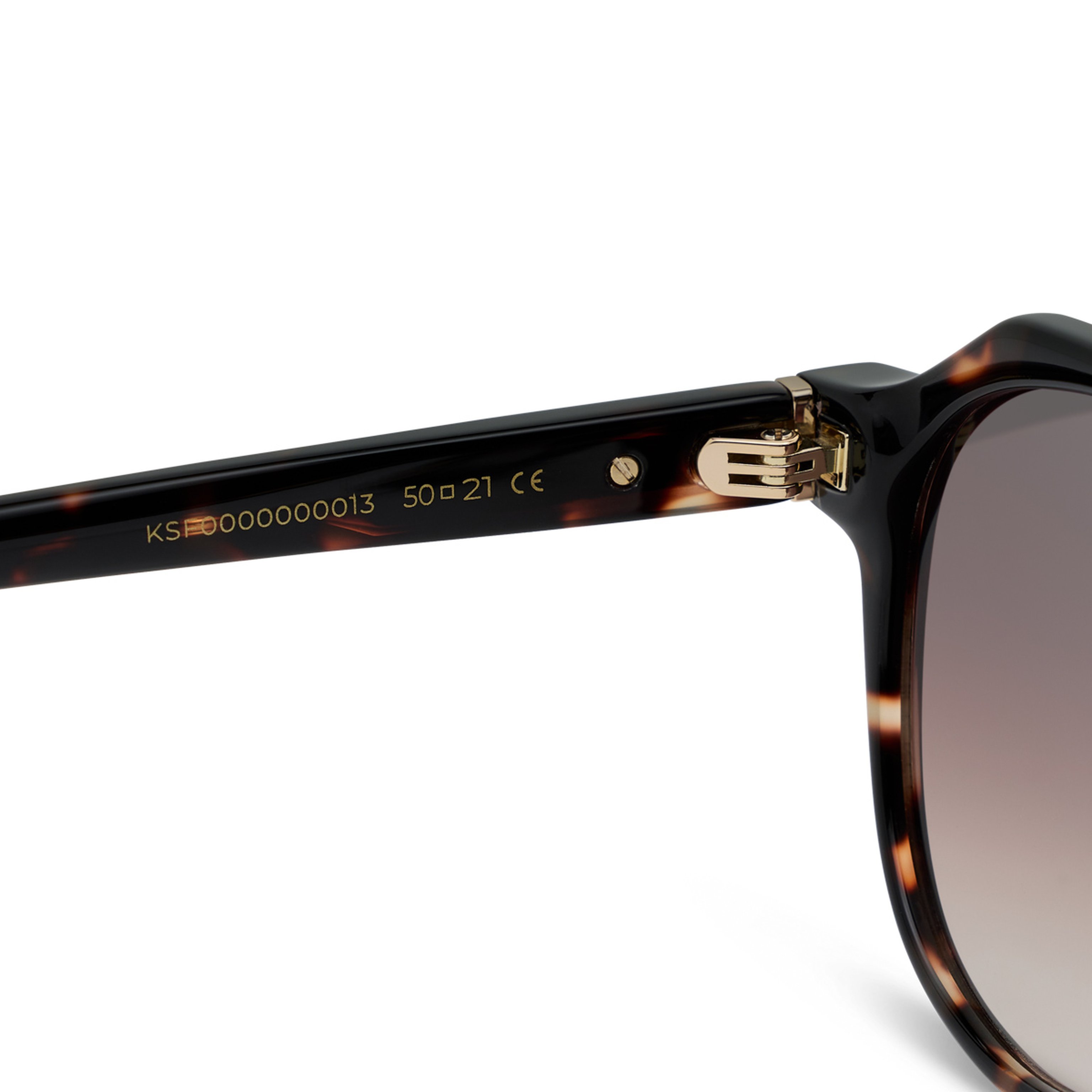Close-up of tortoiseshell sunglasses showing detailed gold hinge and model number etched on the arm. The design appears modern and stylish.