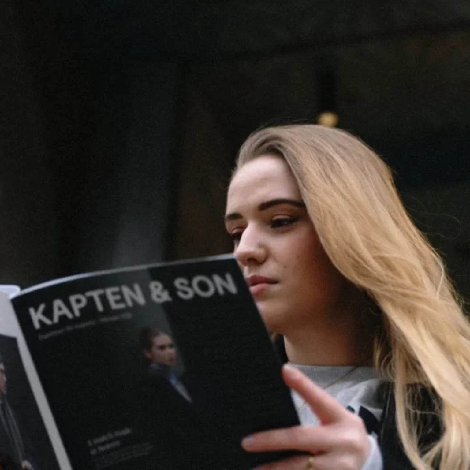frau liest zeitschrift mit kapten & son auf dem cover