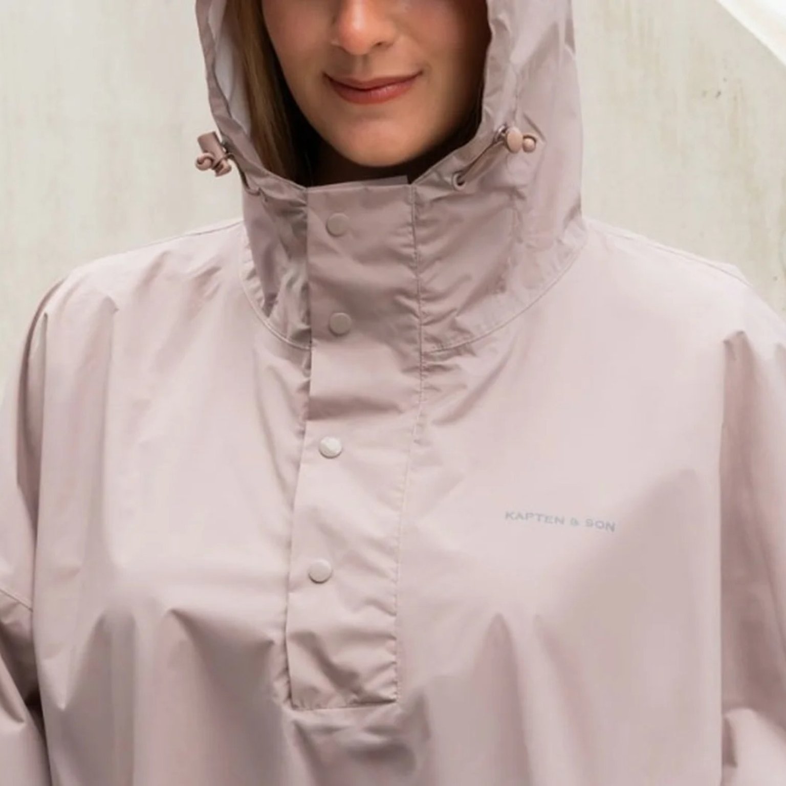 frau trägt rosa farbenes regenponcho von kapten and son