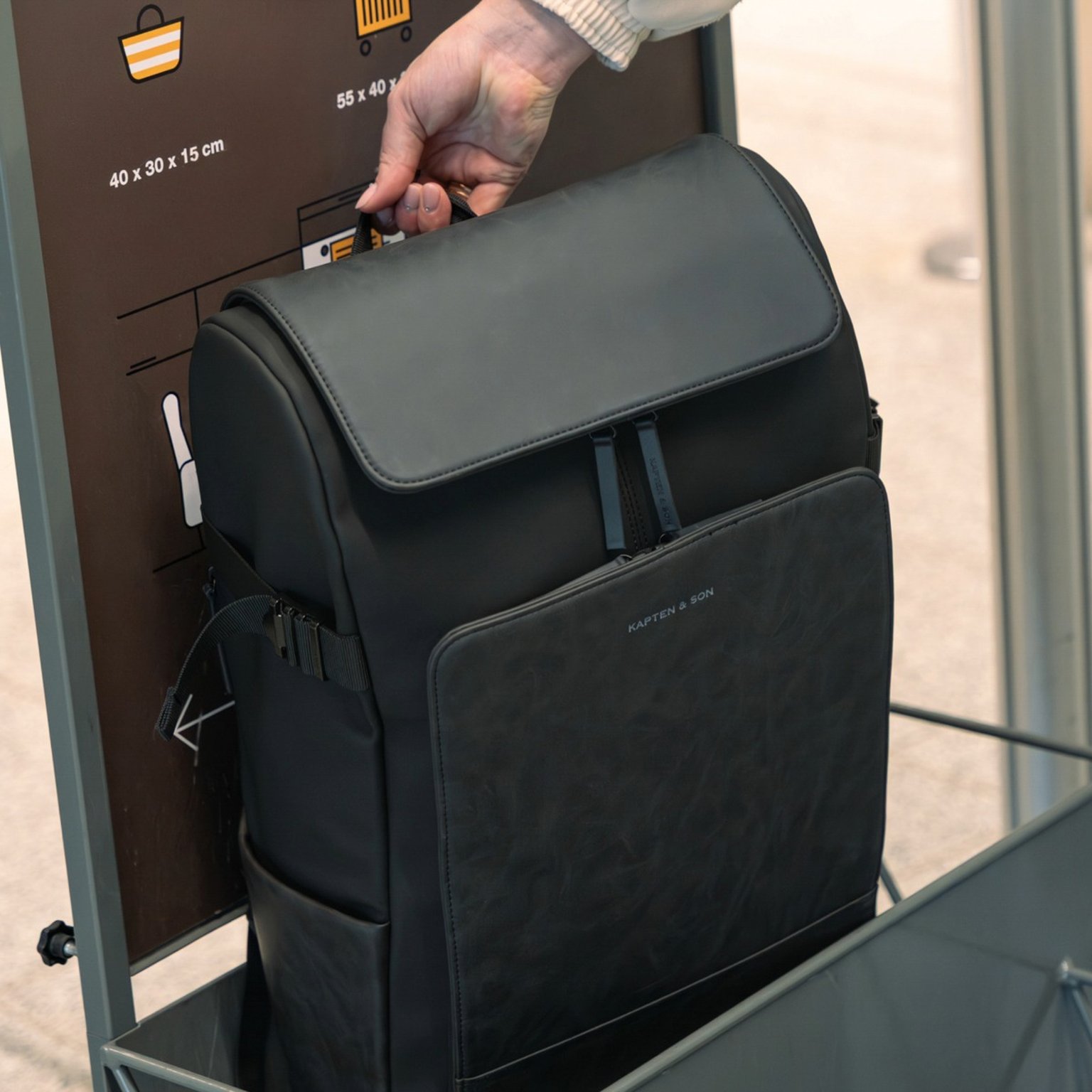 frau misst rucksack am flughafen aus