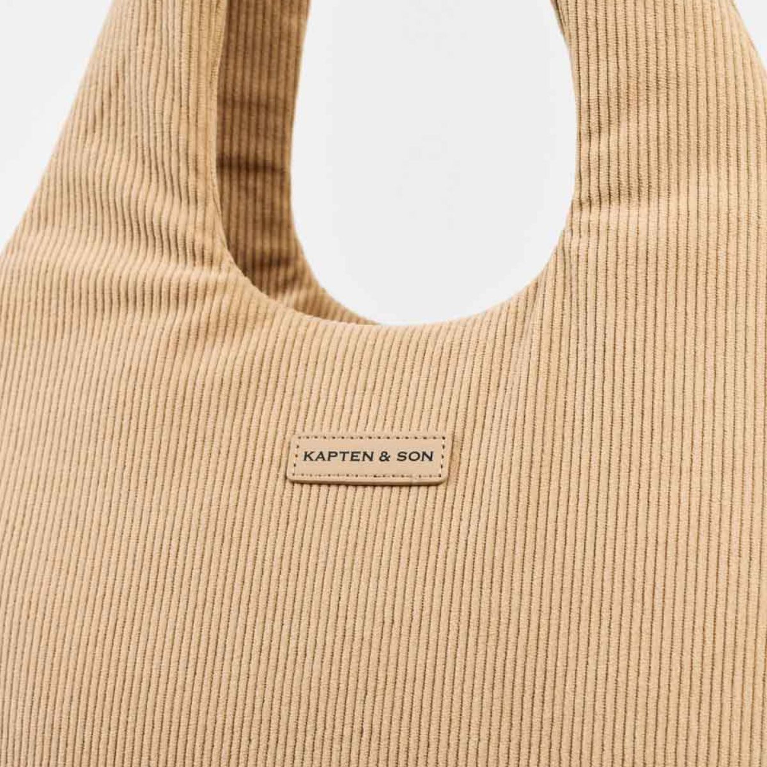 Camel-colored bag made from cotton cord, showcasing a soft texture and casual style.