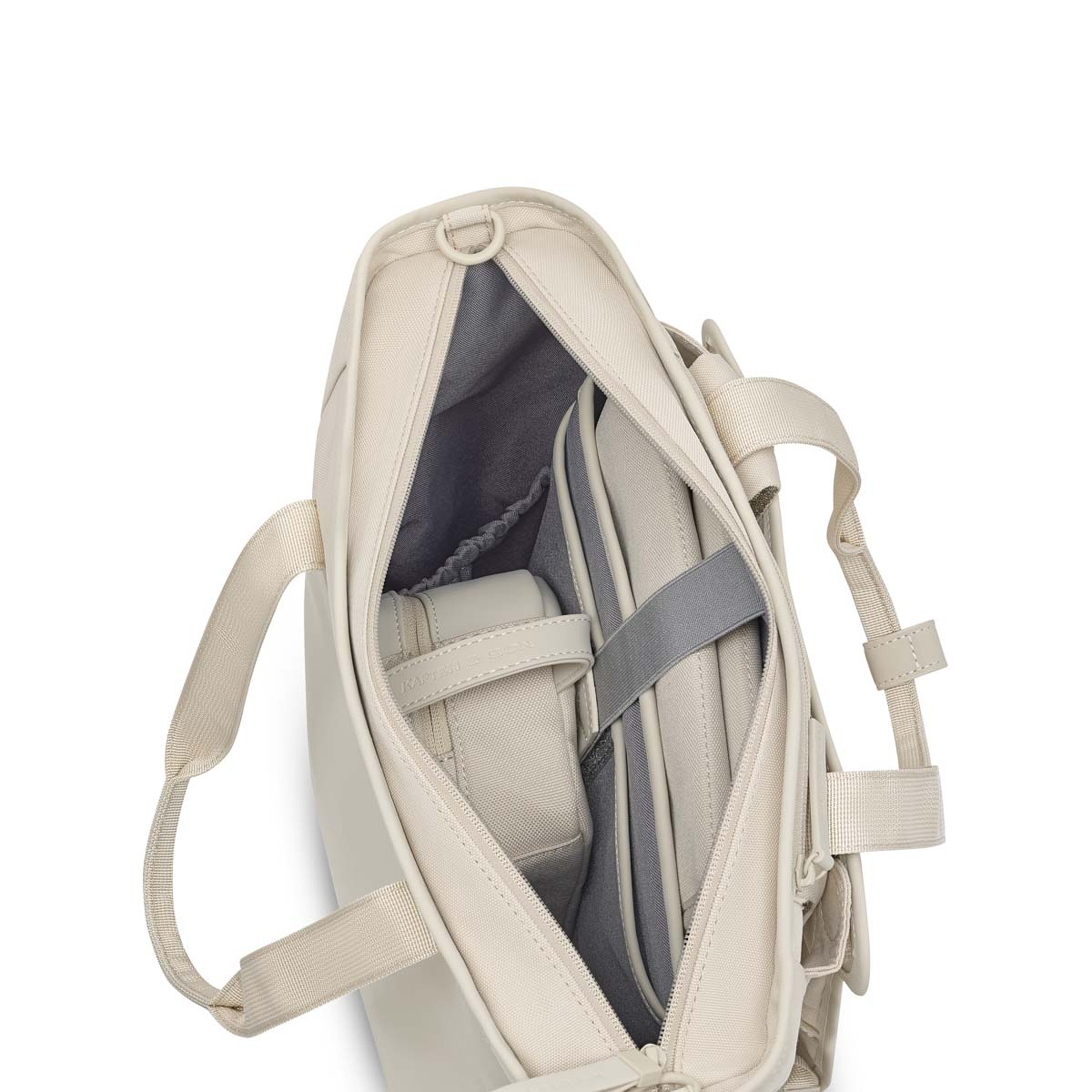 Offene beige Tasche mit sichtbaren Fächern, in der ein grauer Laptop und Wickelzubehör untergebracht sind. Die Tasche verfügt über ordentliche, organisierte Innentaschen.