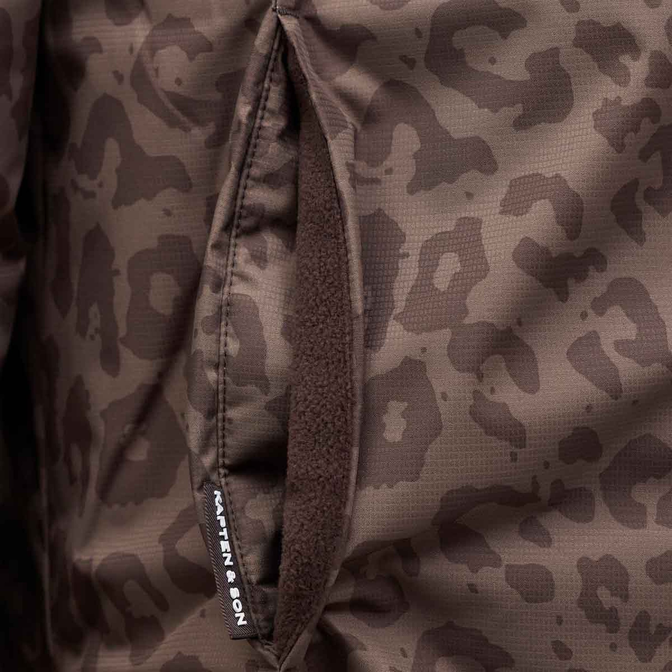 Nahaufnahme einer mit Fleece gefütterten Innentasche einer wendbaren Jacke mit Markenlabel