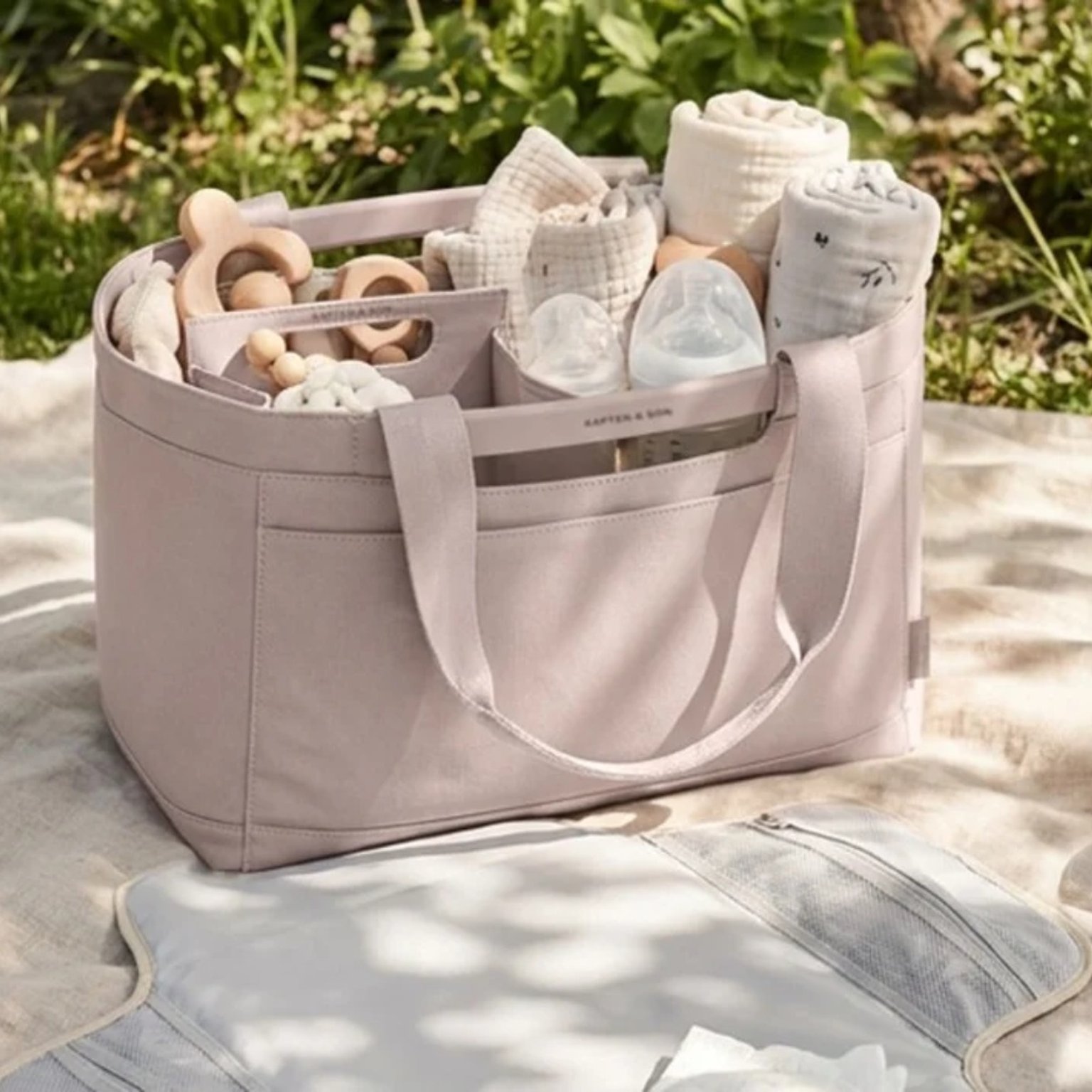 rosa farbener wickelkorb auf einer picknickdecke im freien