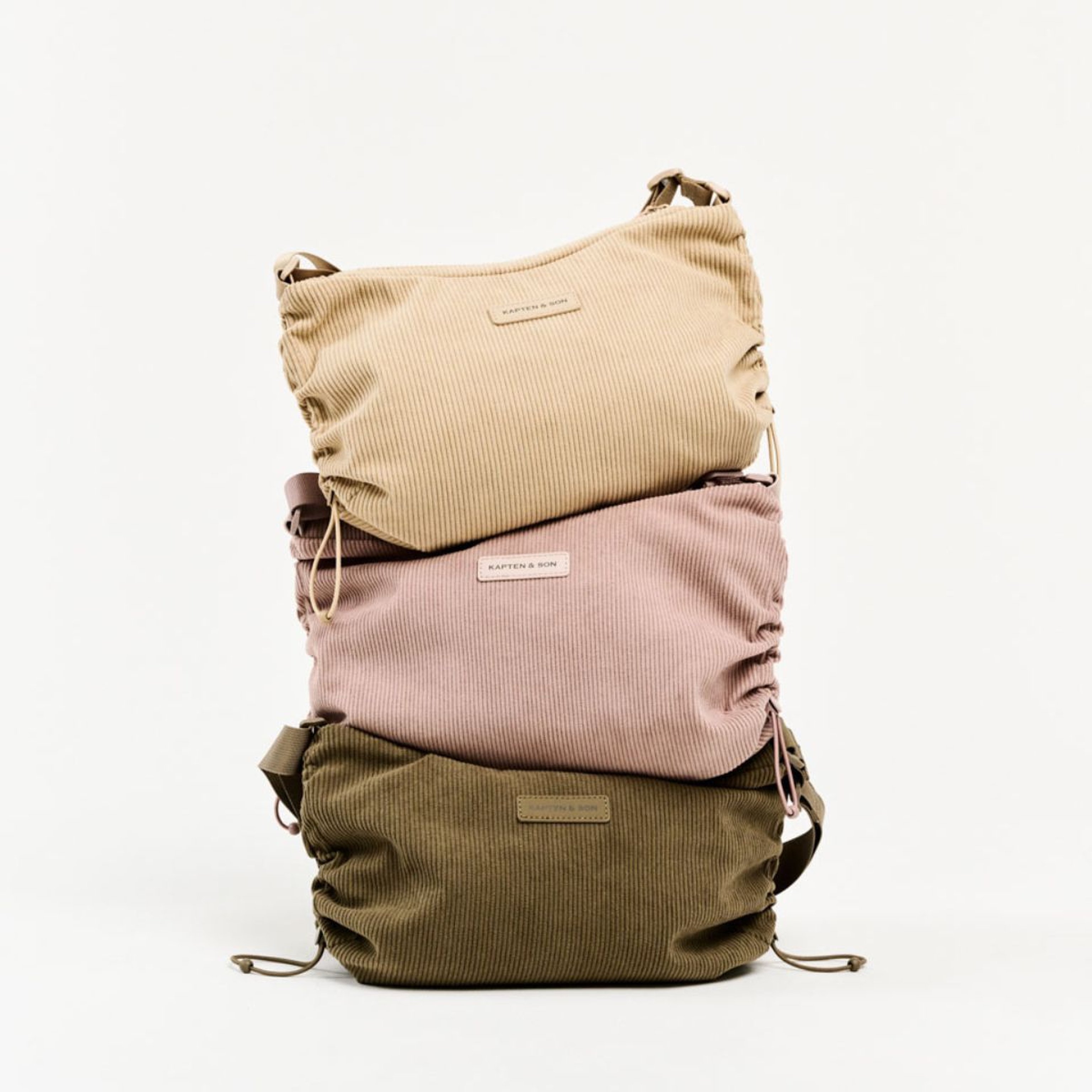 Tres bolsos coloridos apilados, mostrando una vibrante mezcla de tonos y texturas.