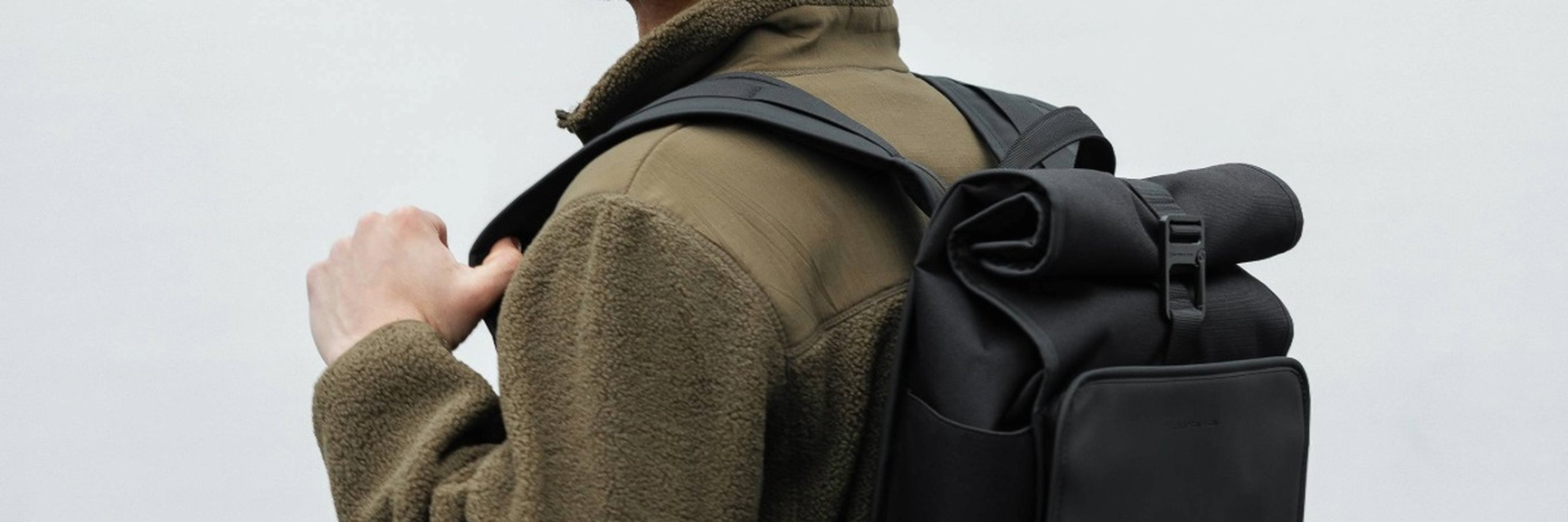 mann trägt rolltop rucksack von kapten & son