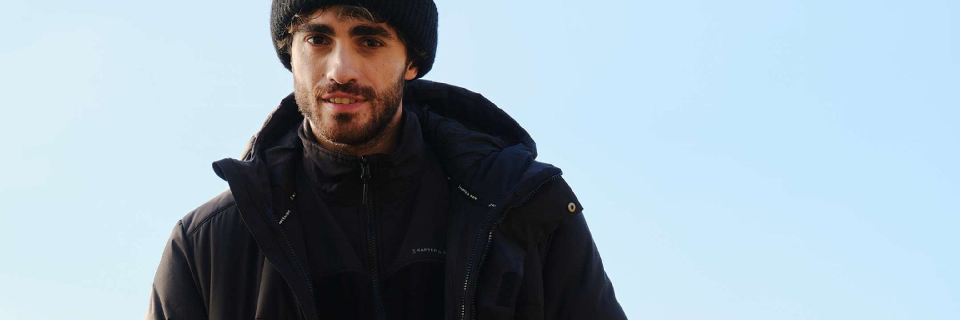 junger mann trägt herren-pufferjacke von kapten and son in schwarz