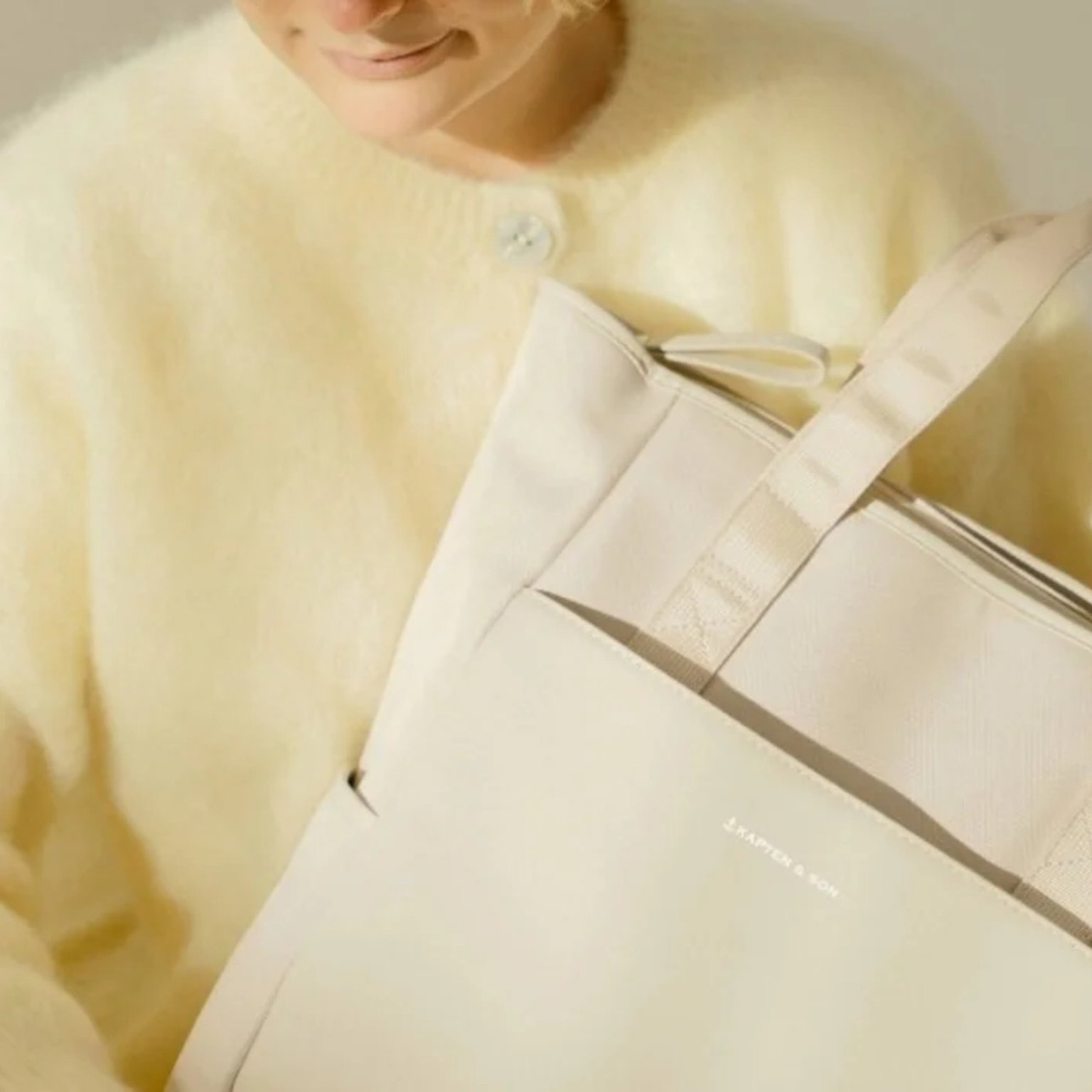 blonde mama hält kapten & son wickelrucksack