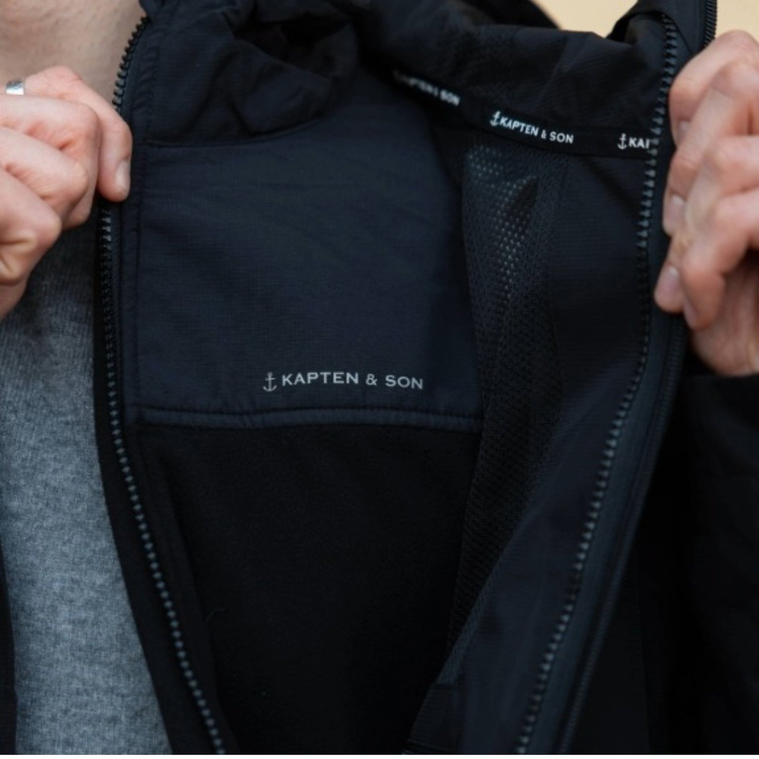 mann enthüllt fleecejacke unter seiner regenjacke