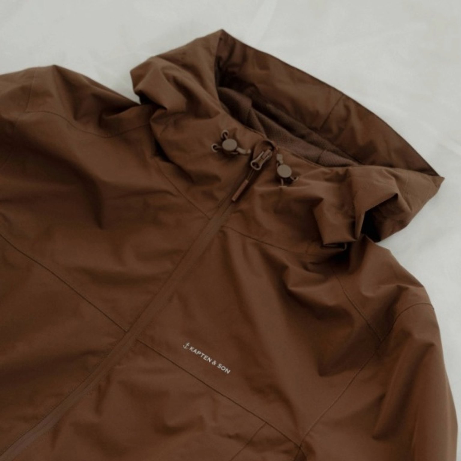 mann enthüllt fleecejacke unter seiner regenjacke