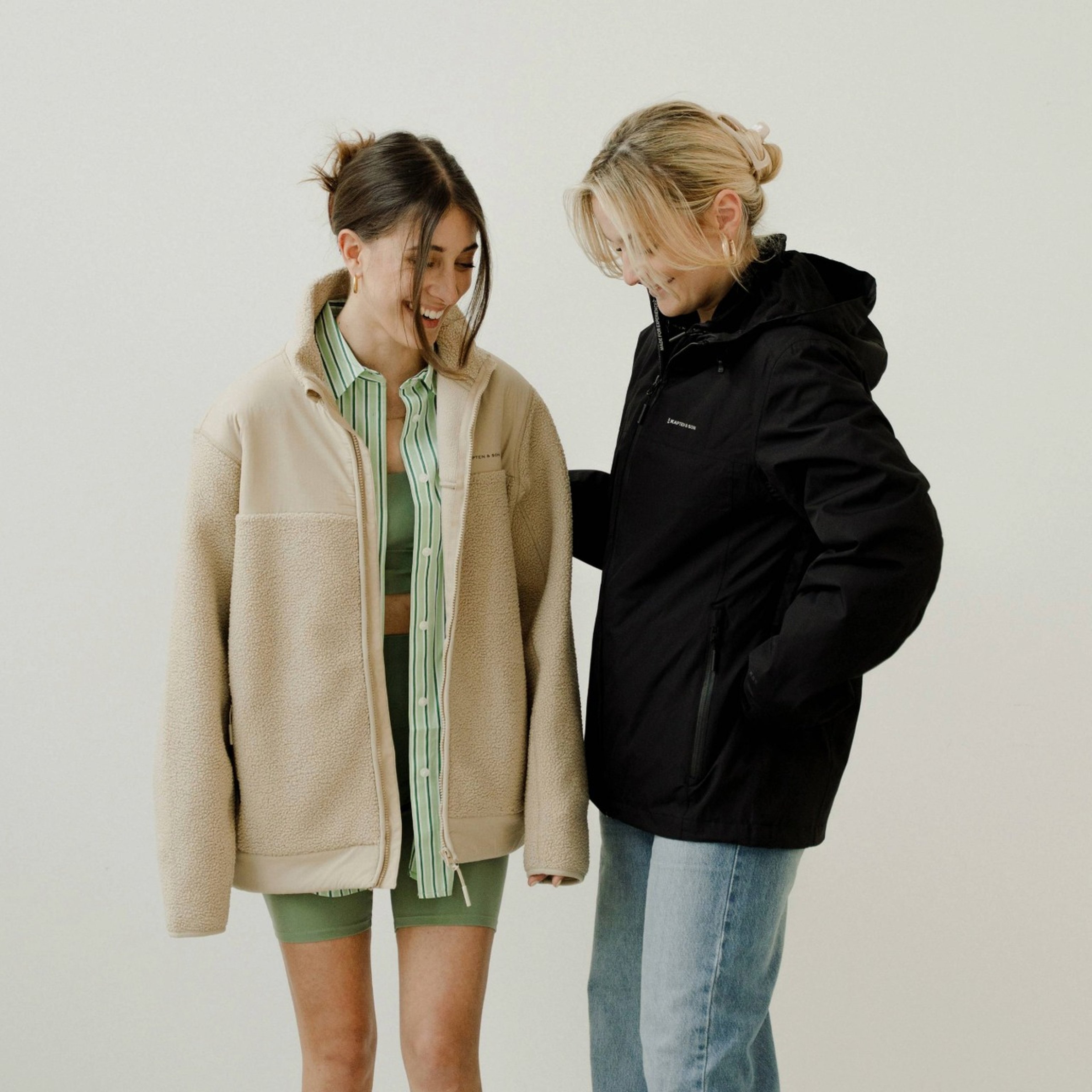 zwei junge frauen tragen kapten and son fleece und regenjacke