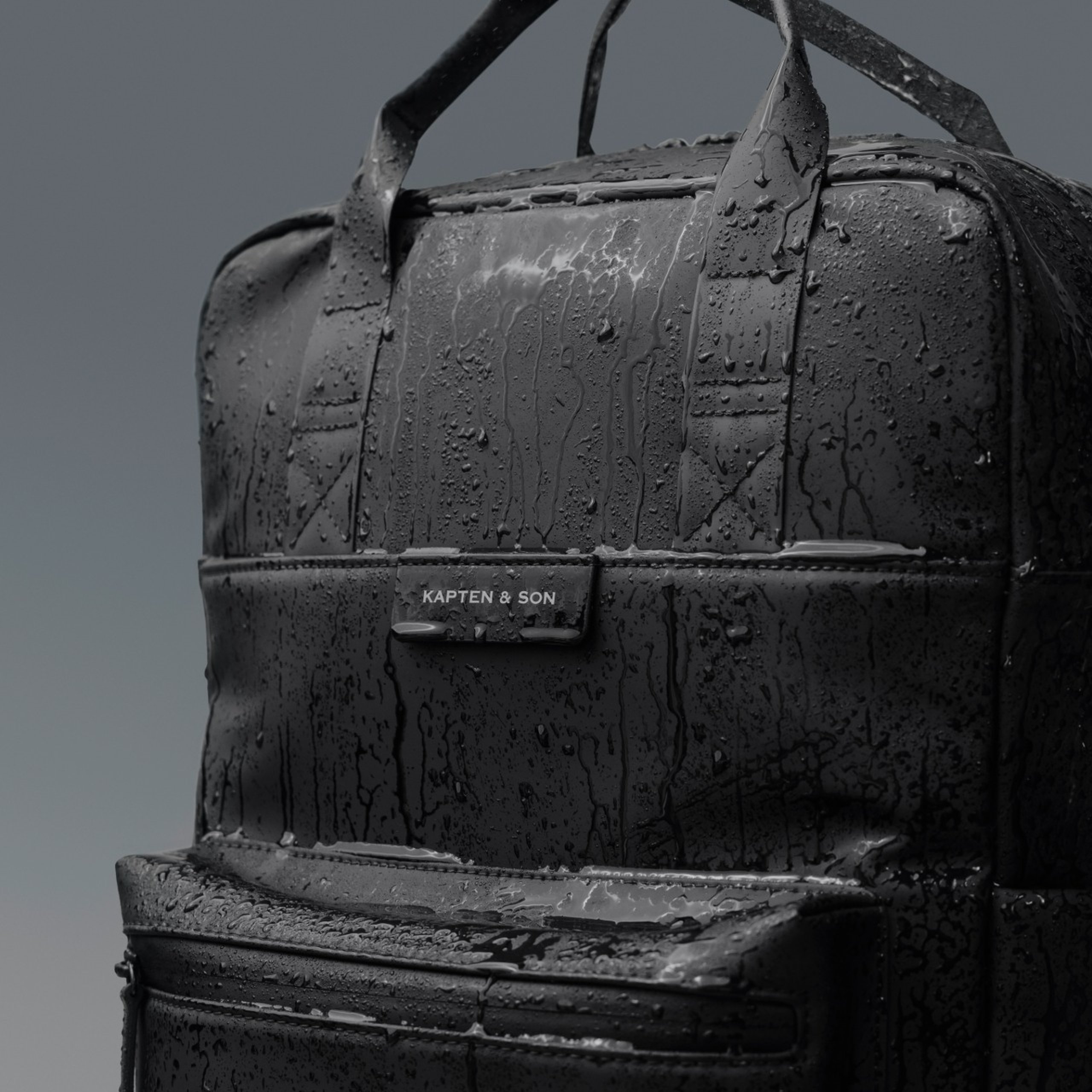 schwarzer rucksack von kapten & son mit wasser bentzt