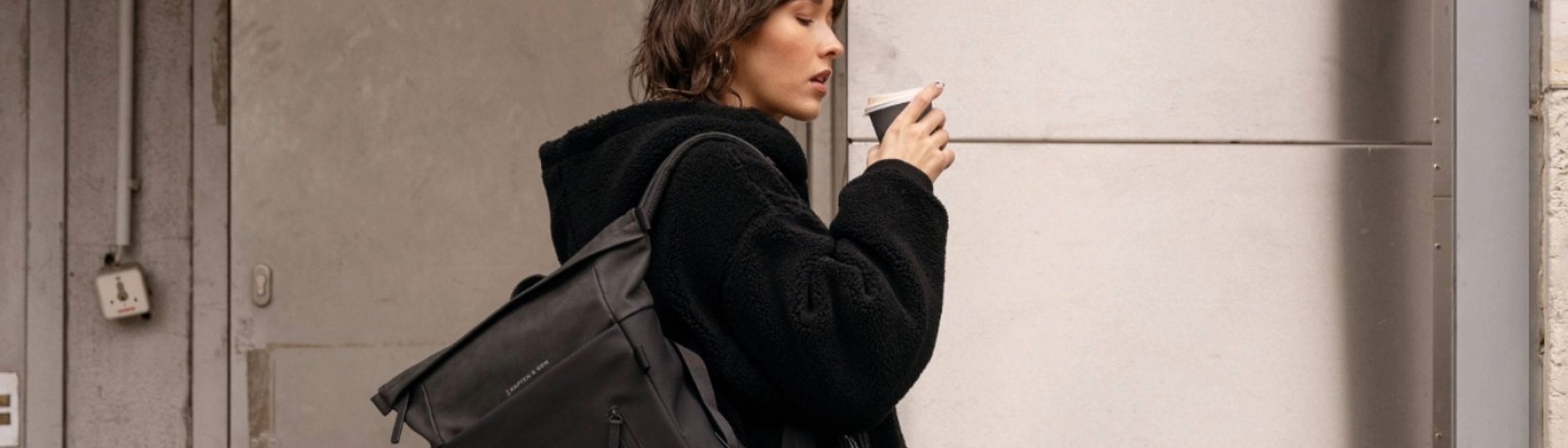junge frau trägt uni rucksack von kapten and son