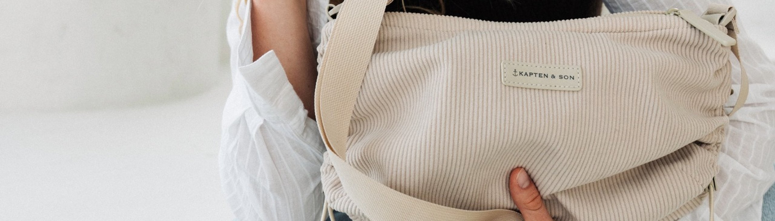 frau trägt eine crossbody bag aus hellem cord material