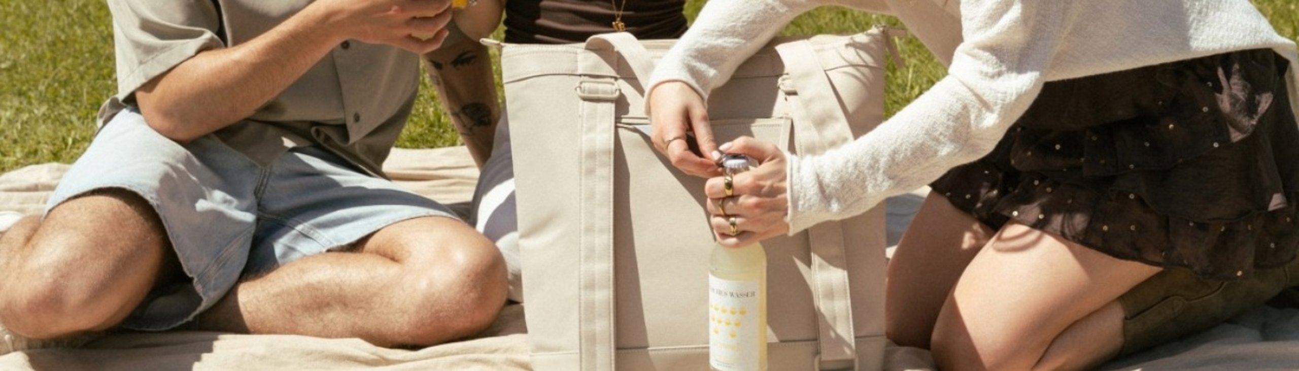 frau öffnet flasche mit flaschenöffner von kapten & son kühltasche