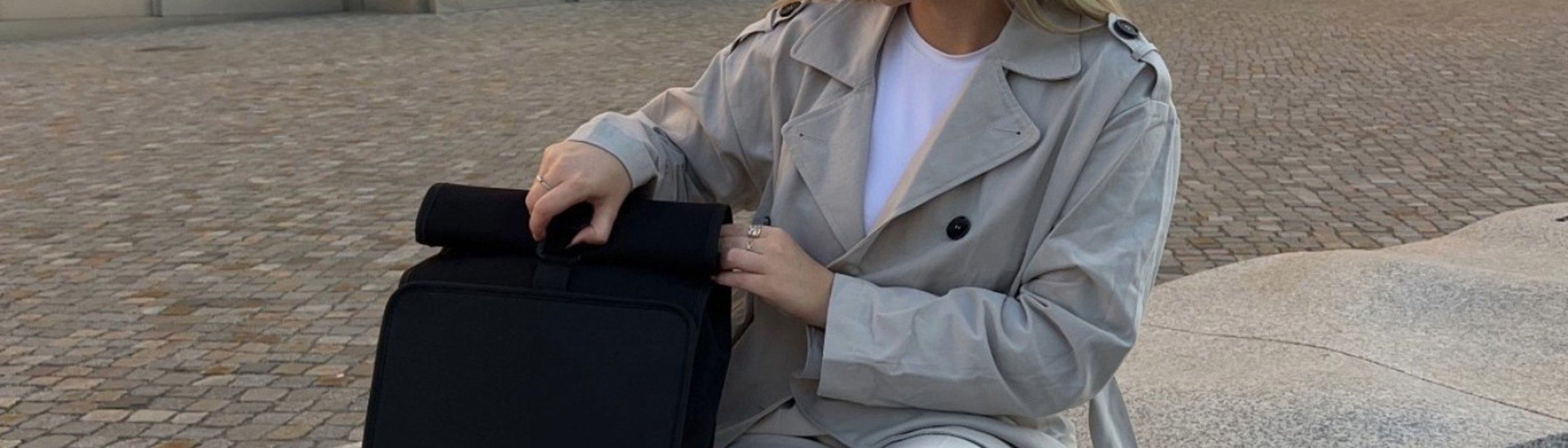 lehrerin öffnet verschluss an ihrem kapten & son rolltop rucksack 