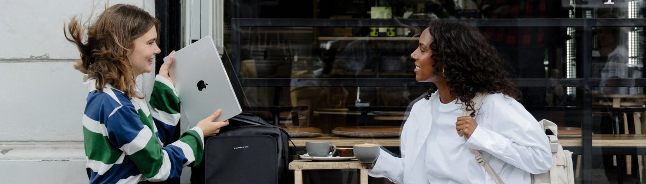 zwei frauen unterhalten sich vor einem cafe