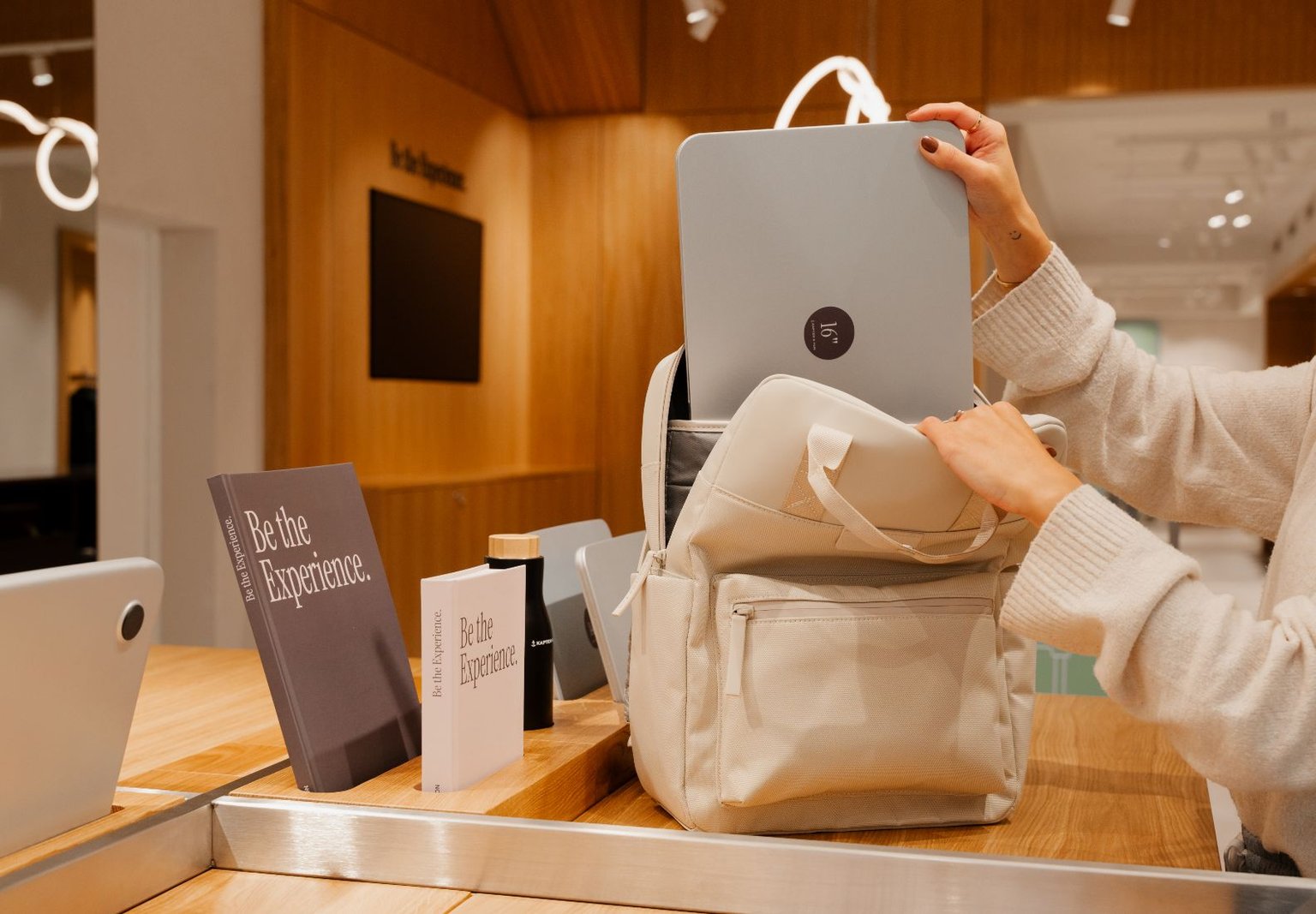 Innenansicht des Kapten & Son Experience Stores – Wandregal mit Taschen, Rucksäcken und Accessoires, Regale mit Reisegepäck und Reisetaschen sowie eine Glasvitrine mit Uhren und Schmuck