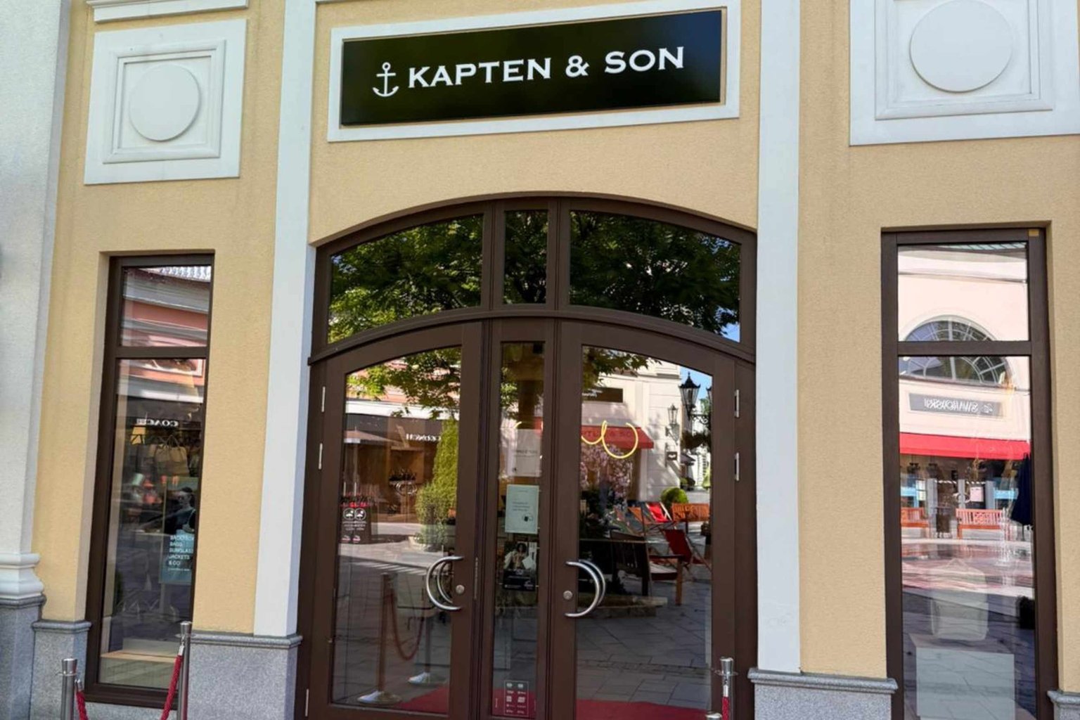 Außenansicht eines Kapten & Son Stores mit großem Schaufenster und Blick ins Ladeninnere