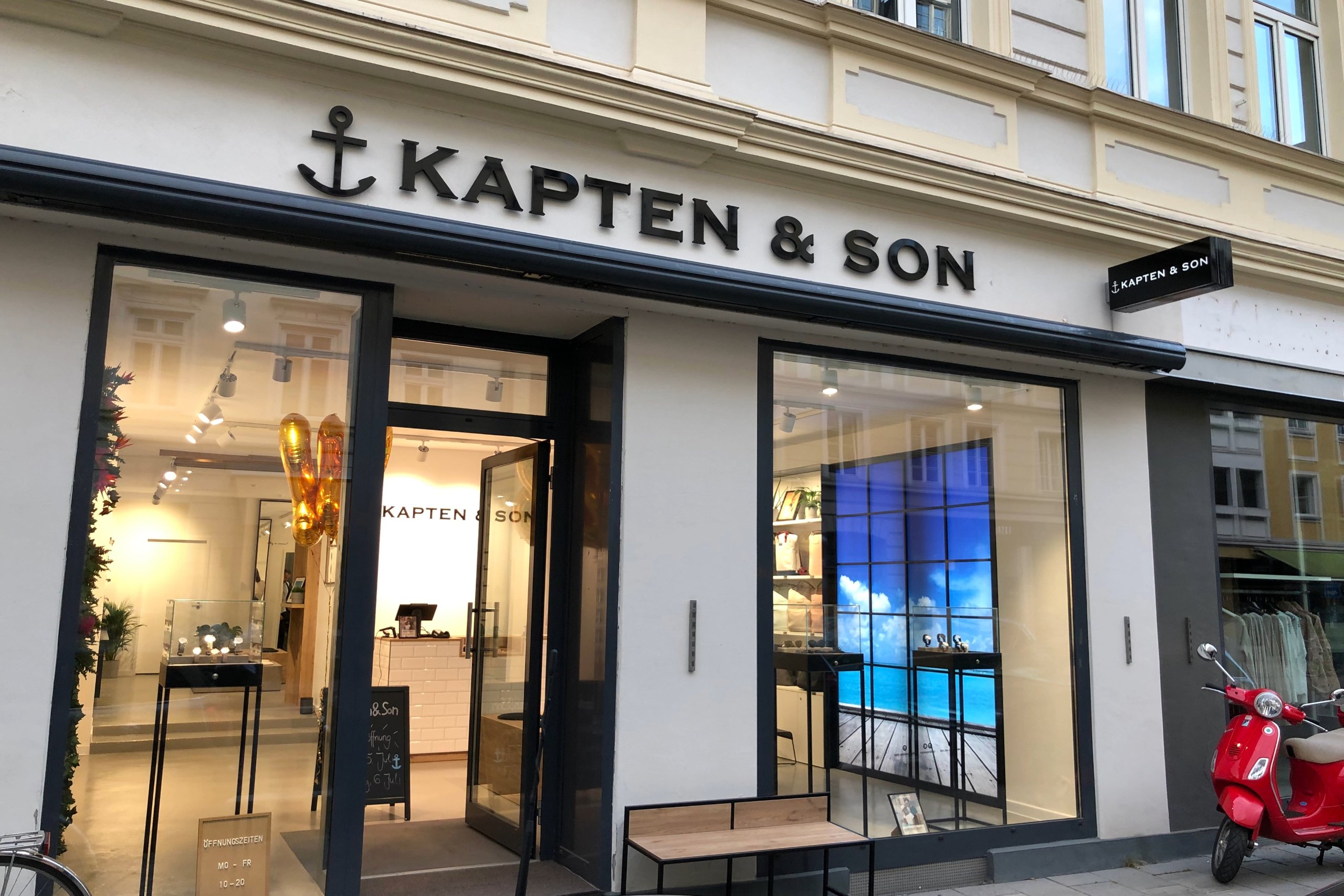 Kapten & Son Store – storefront with illuminated logo, backpacks, bags and luggage displayed in the shop windows