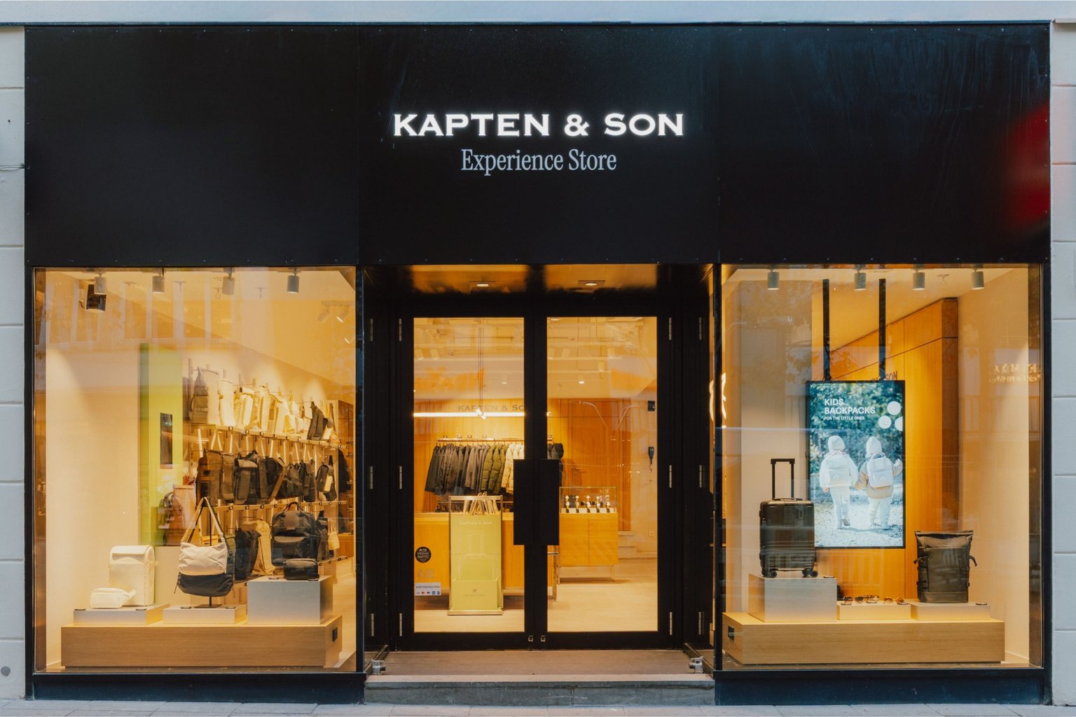 Außenansicht eines Kapten & Son Stores mit großem Schaufenster und Blick ins Ladeninnere