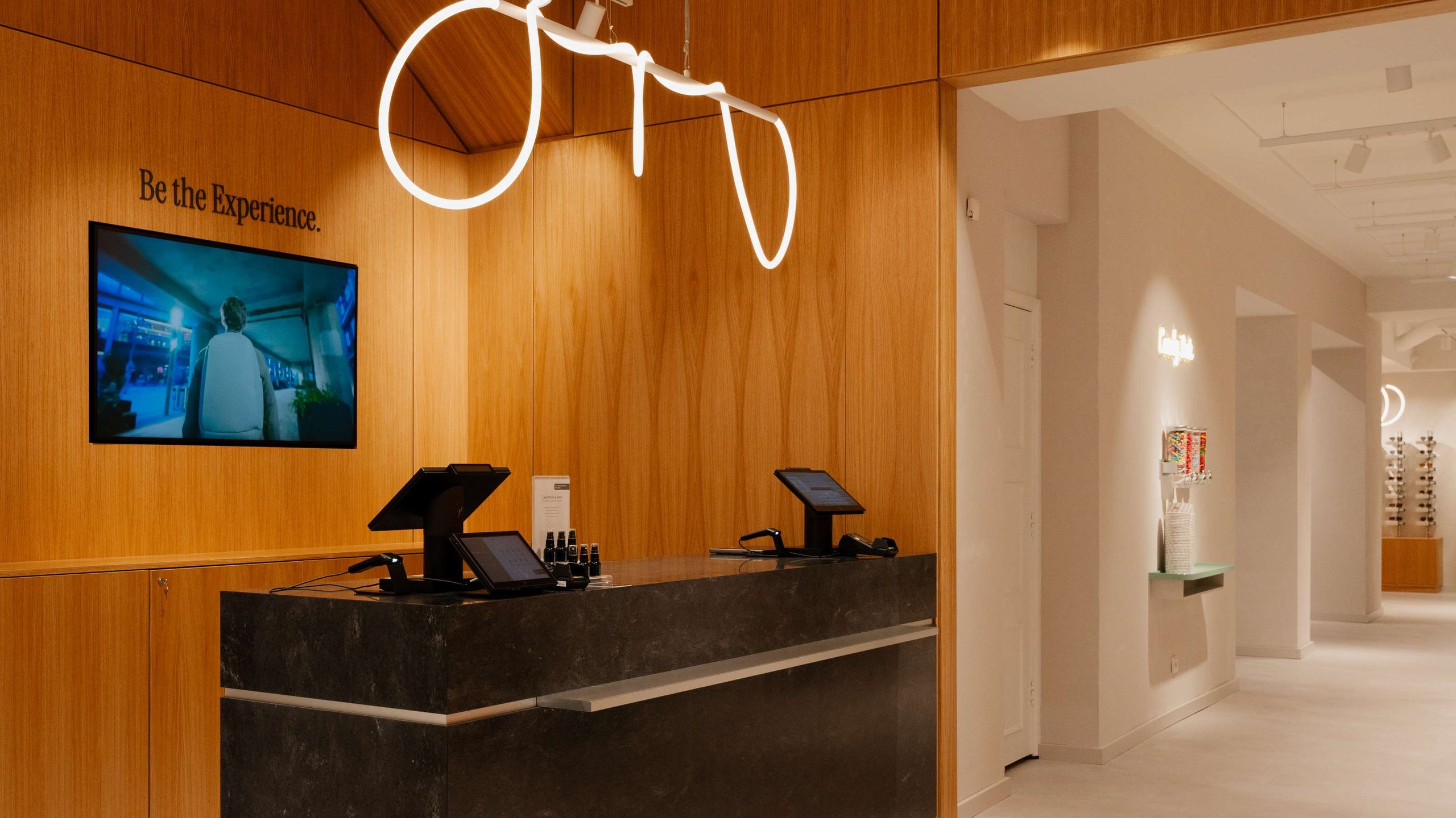 Kapten & Son Experience Store – Ladenfront mit beleuchtetem Logo, Rucksäcken, Taschen und Reisegepäck in den Schaufenstern