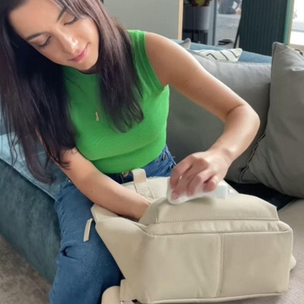 frau reinigt rucksack mit schmutzradierer