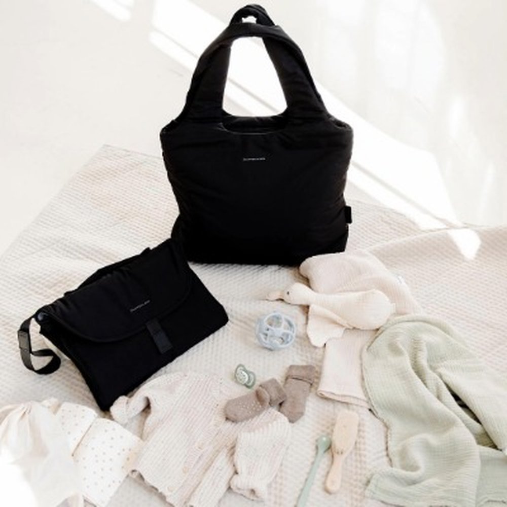 wickelplatz mit wickelrucksack, unterlage und babykleidung