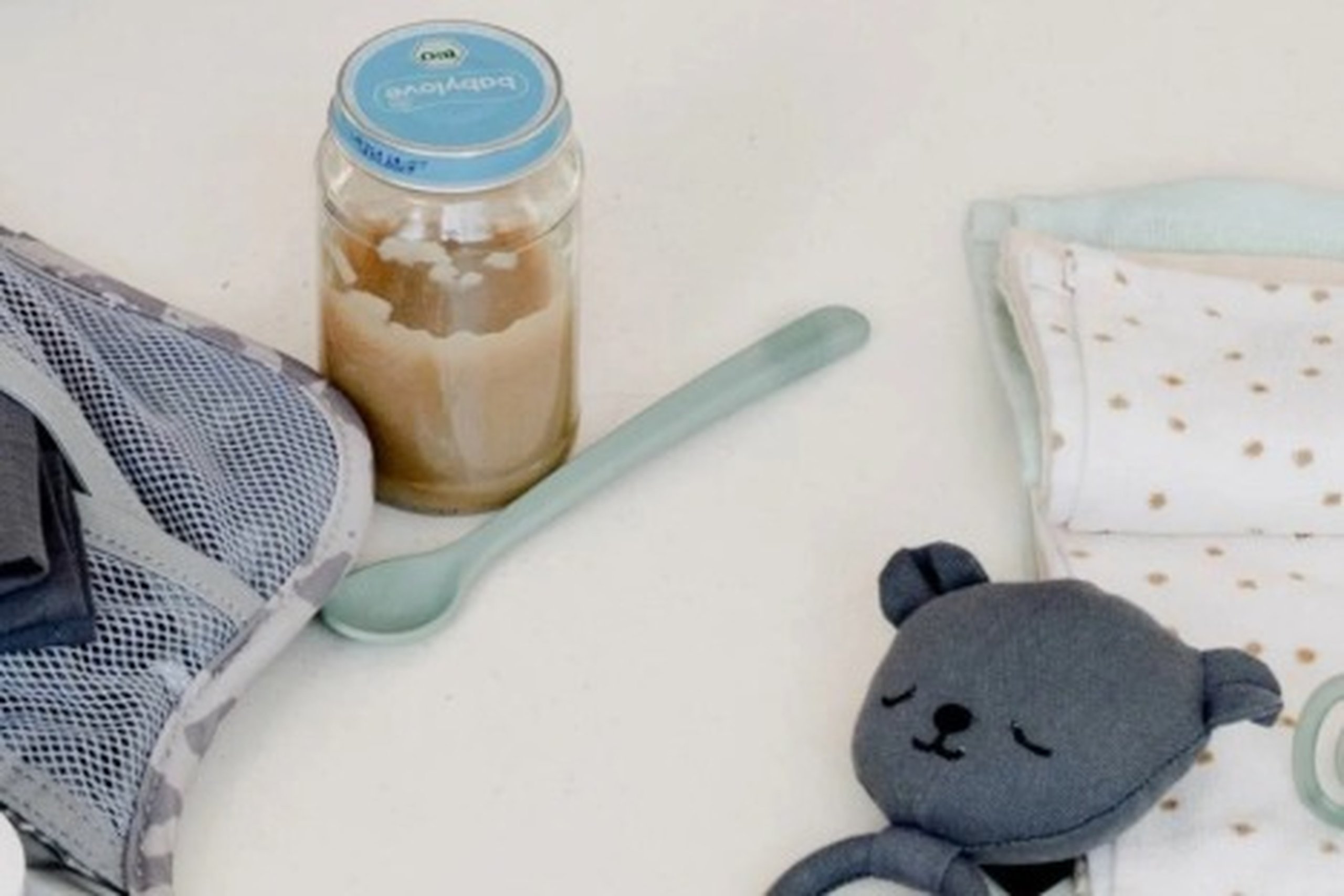 glas mit babynahrung, löffel und spielsachen