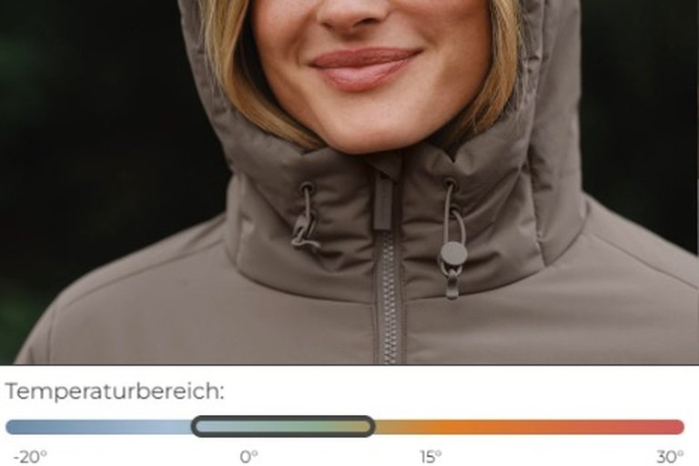 Ein Mann und eine Frau stehen in einer verschneiten Waldlandschaft und tragen passende taupefarbene Outdoorjacken von Kapten & Son.