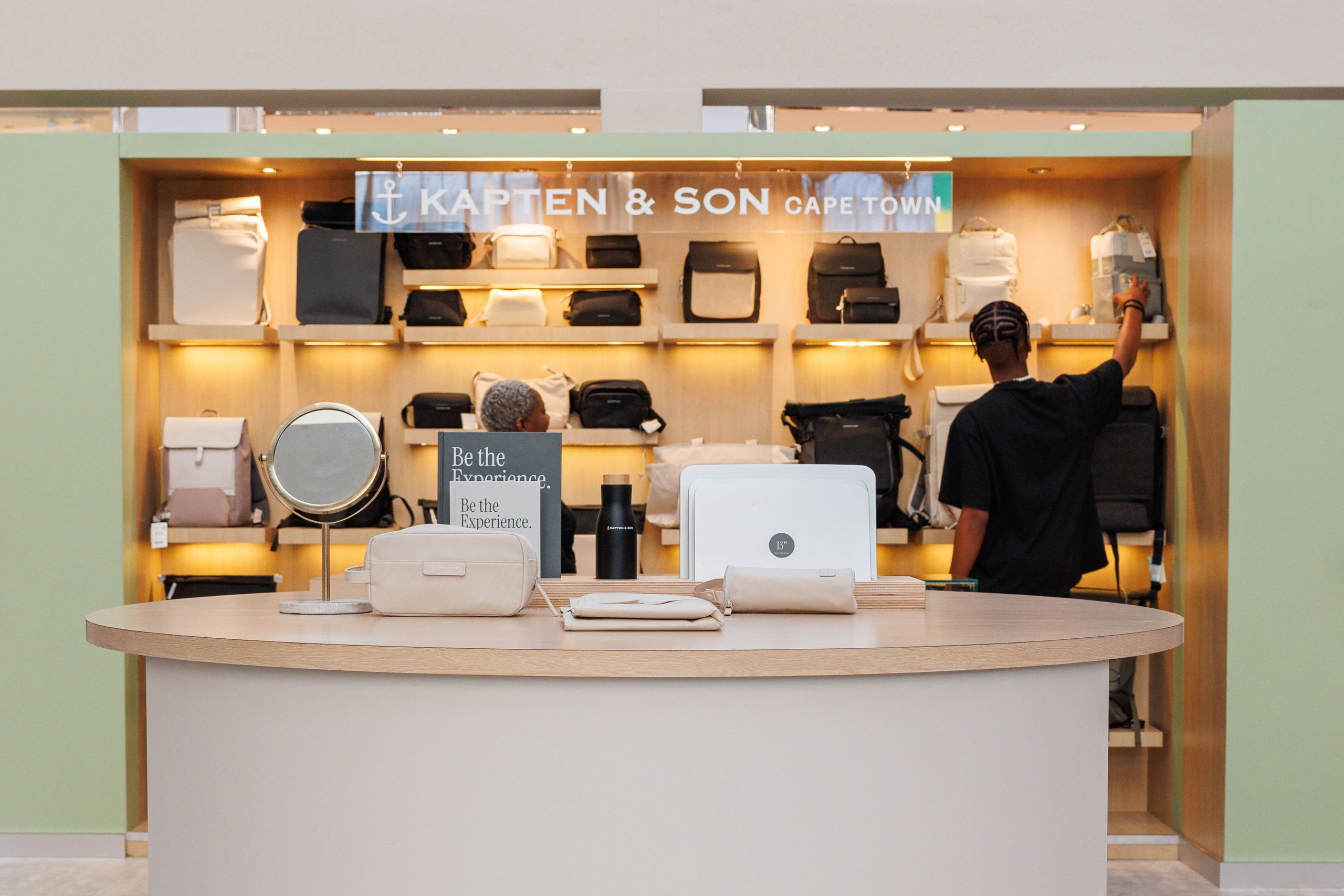 Kapten & Son Experience Store – storefront with illuminated logo, backpacks, bags and luggage displayed in the shop windows
