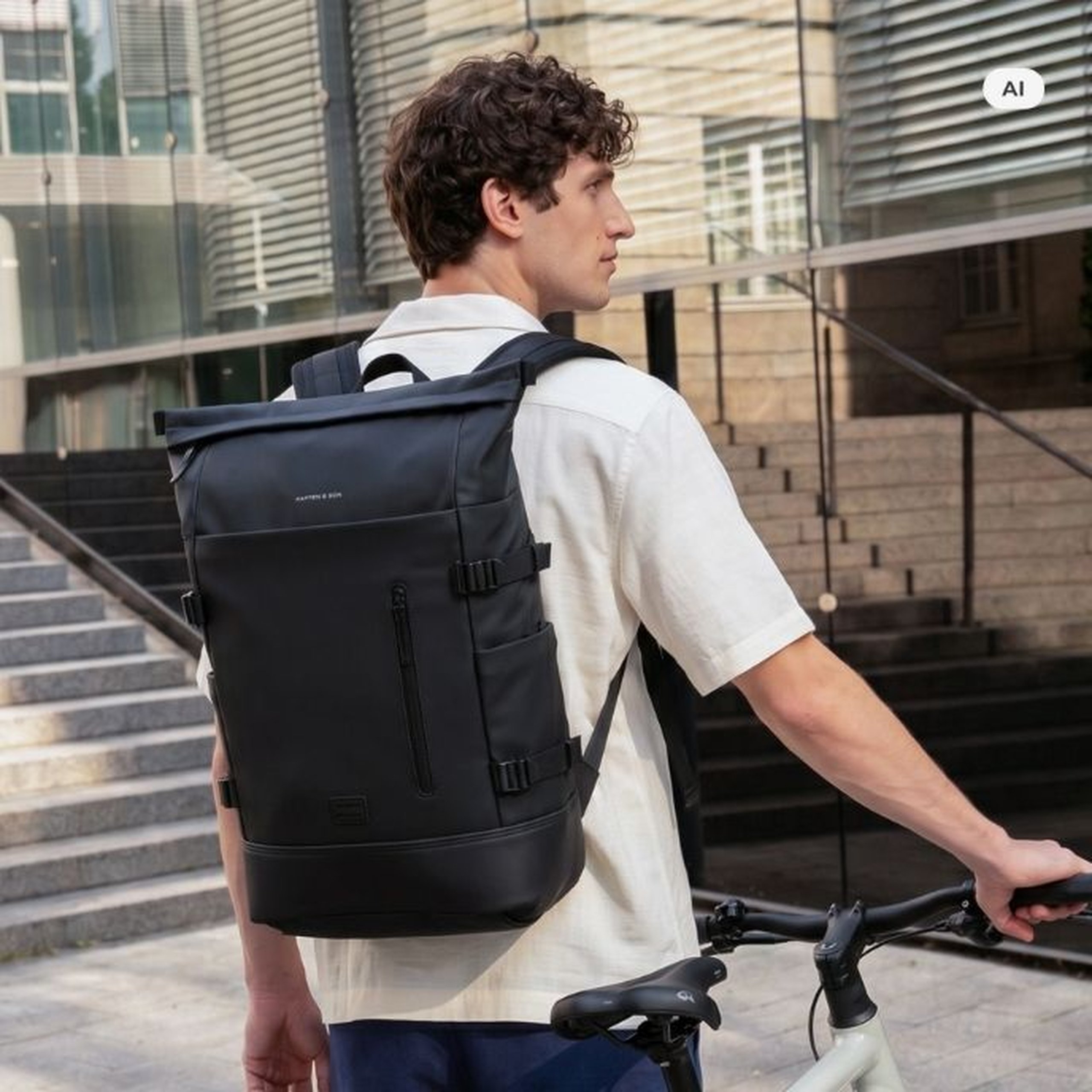 AI Generated: Ein Mann mit einem schwarzen Kapten & Son Rolltop-Rucksack hält eine schwarze Kapten & Son Trinkflasche und steht neben einem weißen Fahrrad vor einem modernen Gebäude.