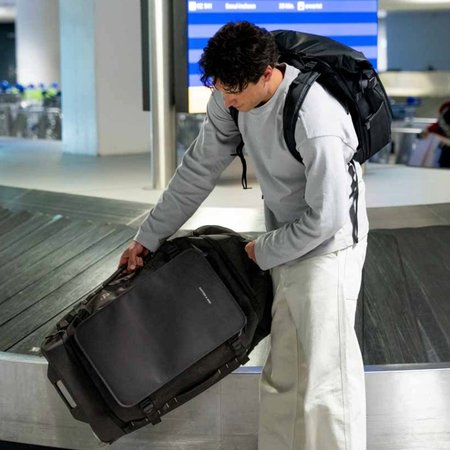 Man haalt een reistas van de bagageband op de luchthaven