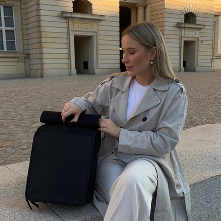 lehrerin öffnet ihren rolltoprucksack