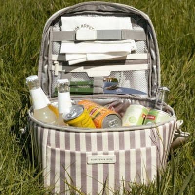 eine külhtasche von kapten & son liegt im gras und ist mit getränken gefüllt