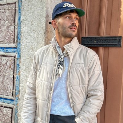 junger mann trägt beige pufferjacke von kapten and son