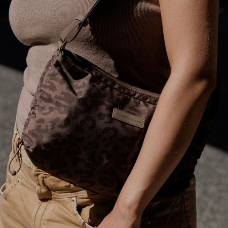 junge frau trägt eine kapten and son crossbody bag mit leoparden muster
