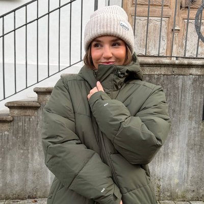 frau trägt olive grüne winter puffer jacke